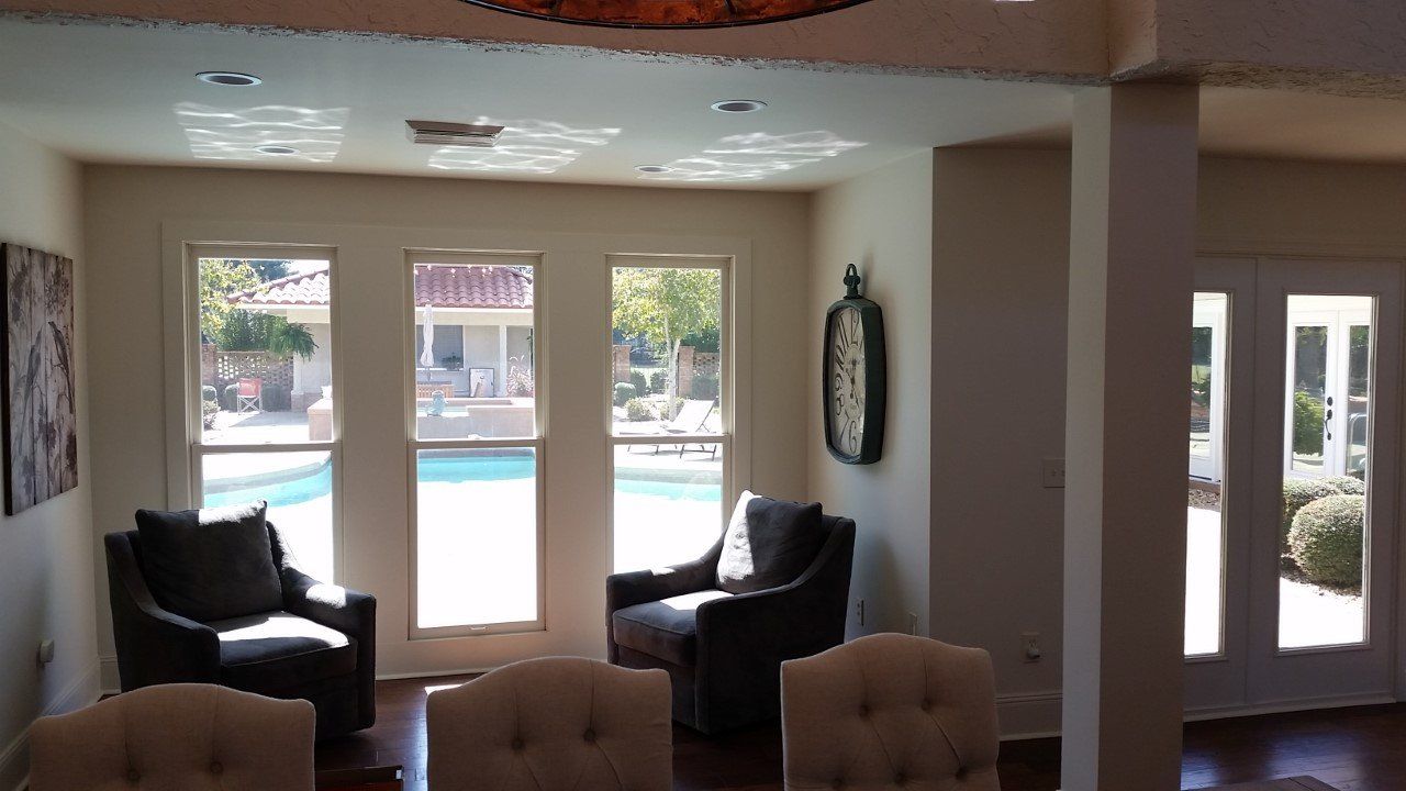 A living room with chairs and a clock on the wall