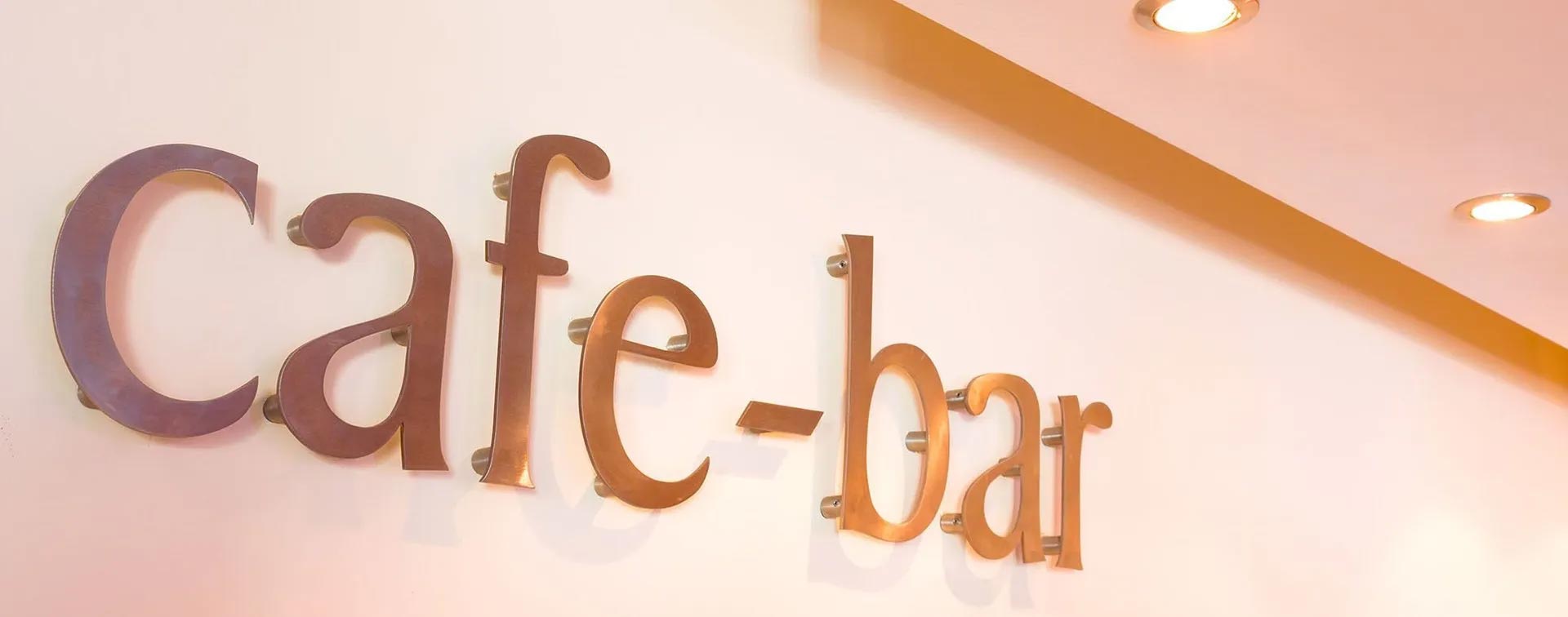 A close up of a cafe bar sign on a wall