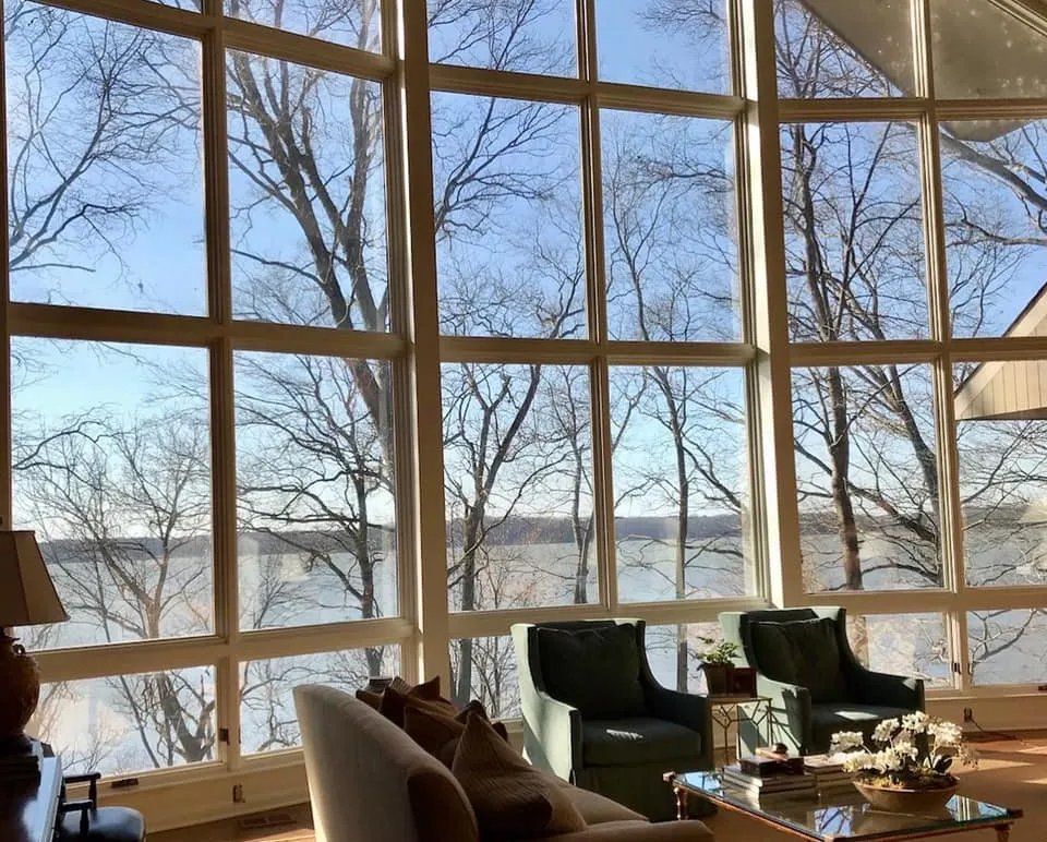 A living room with a lot of windows and a view of trees