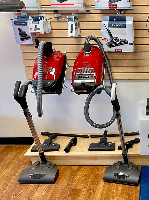 Two vacuum cleaners are on display in a store.