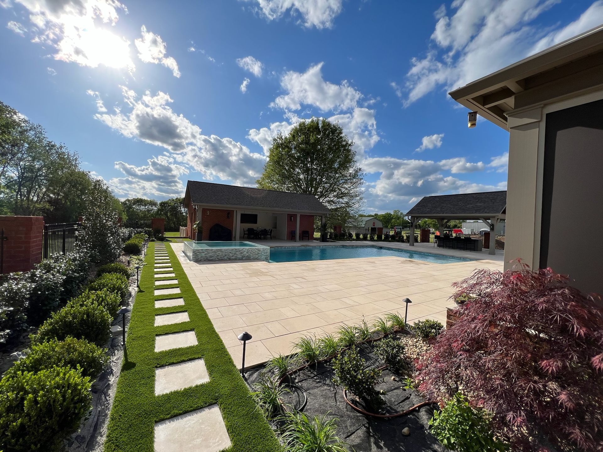There is a large swimming pool in the backyard of a house.