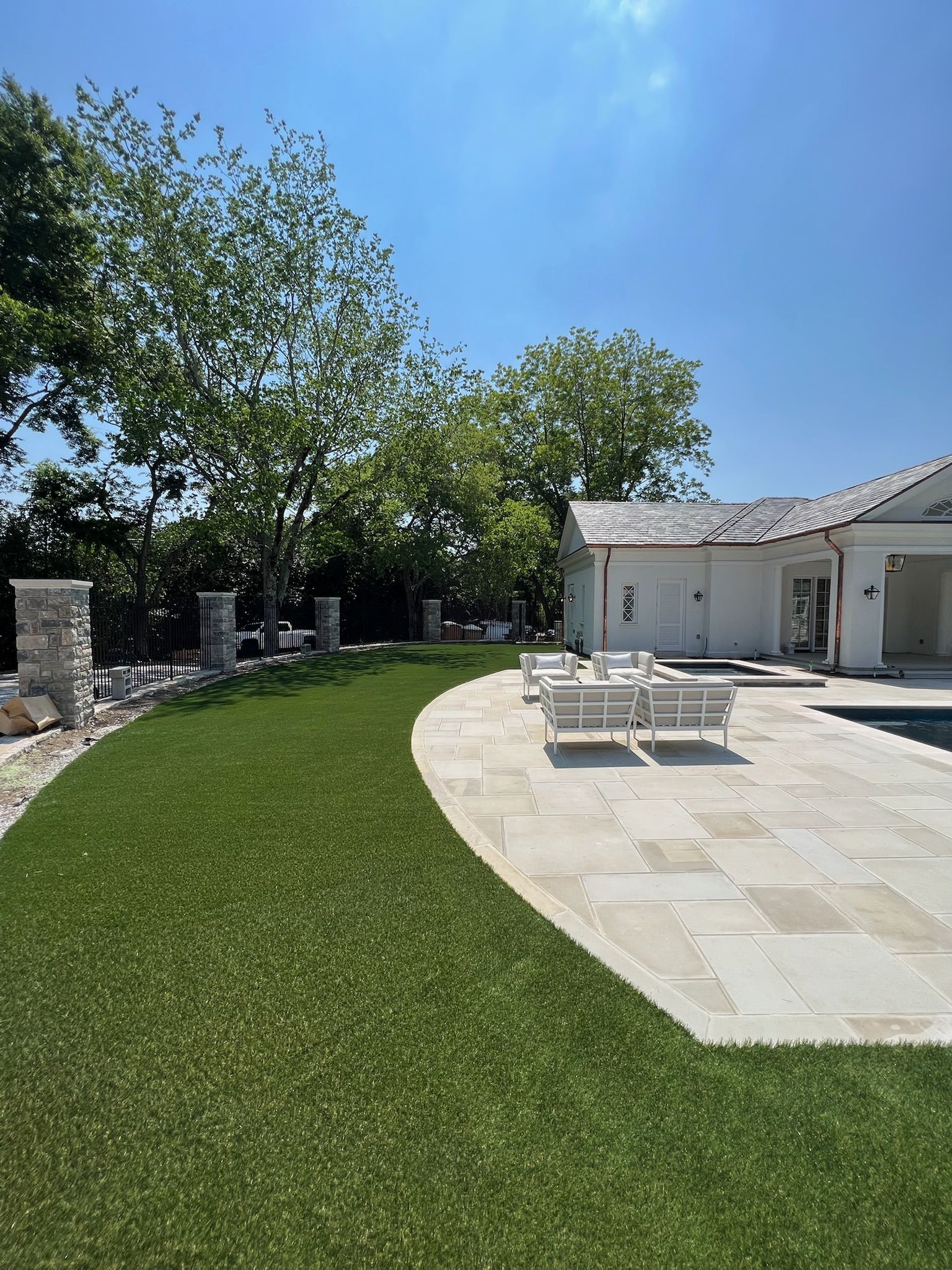 There is a swimming pool in the backyard of a house.