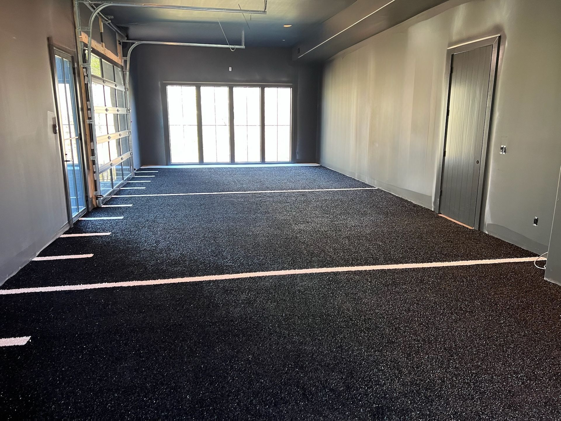 A large room with a lot of windows and a black floor