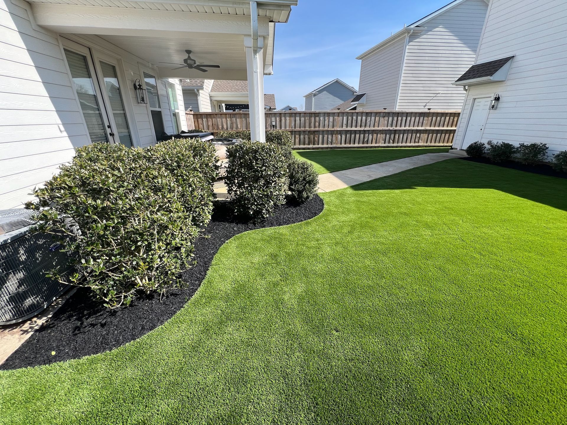 A white house with a lush green lawn in front of it.