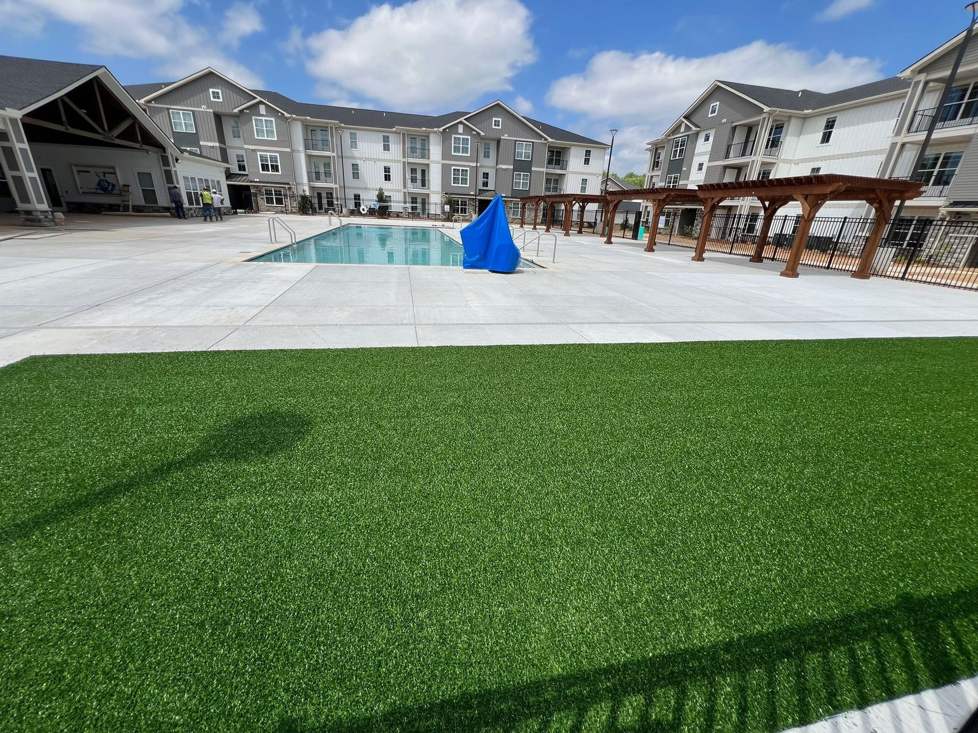 There is a large swimming pool in the middle of a residential area.