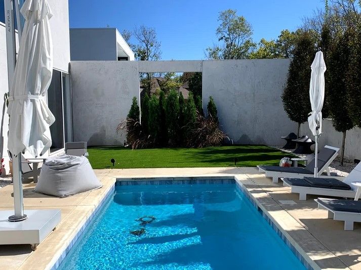 A large swimming pool surrounded by chairs and umbrellas