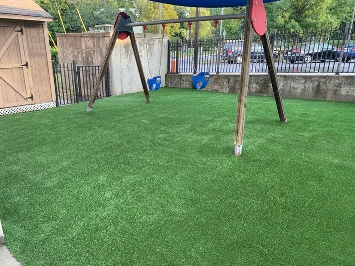 A swing set is sitting on top of a lush green lawn.