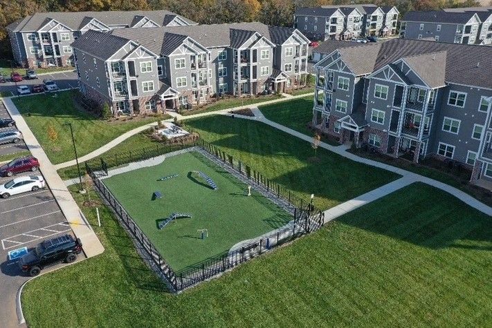 An aerial view of a large apartment complex with a soccer field in the middle.