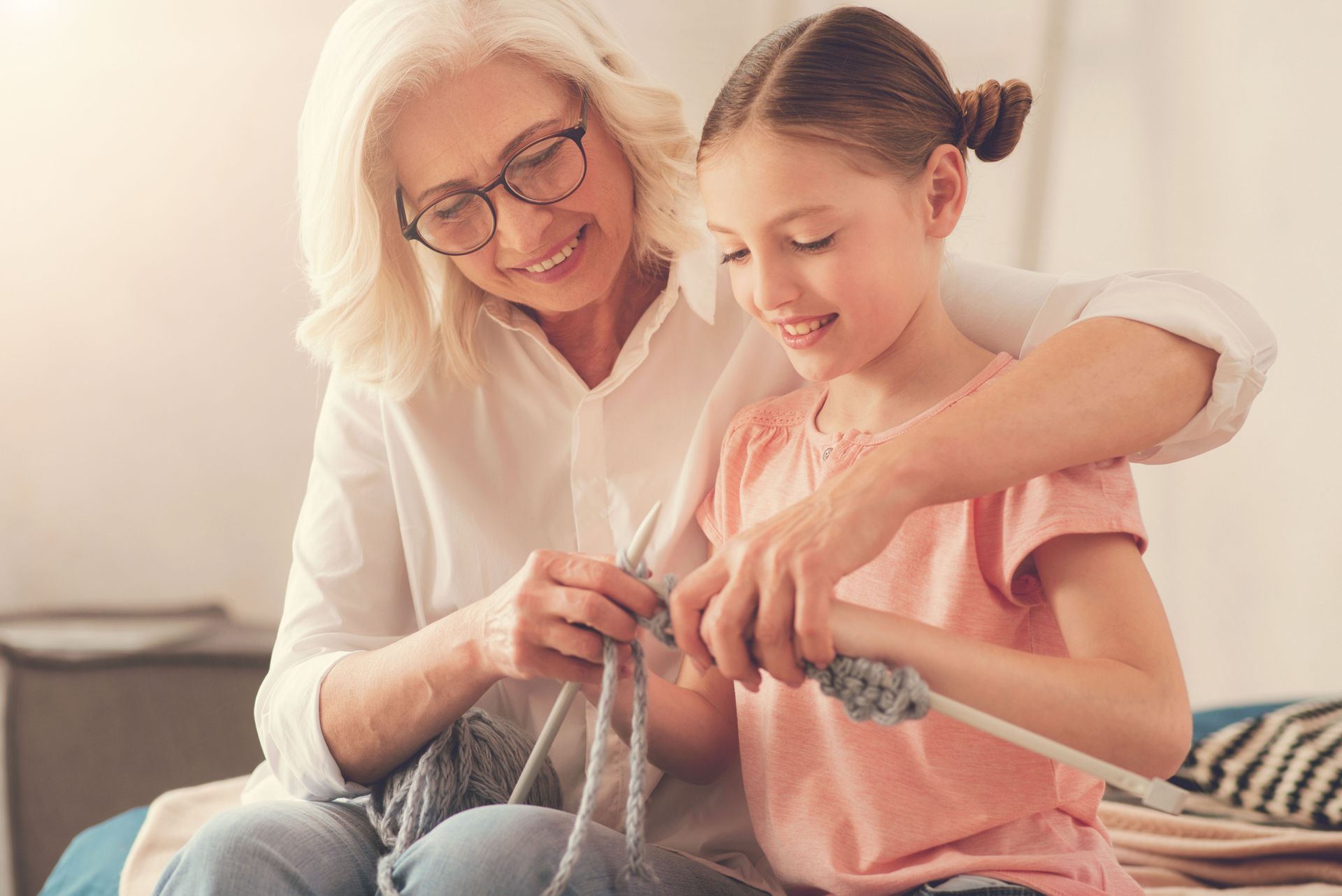 grandma teaching her granddaughter to crochet