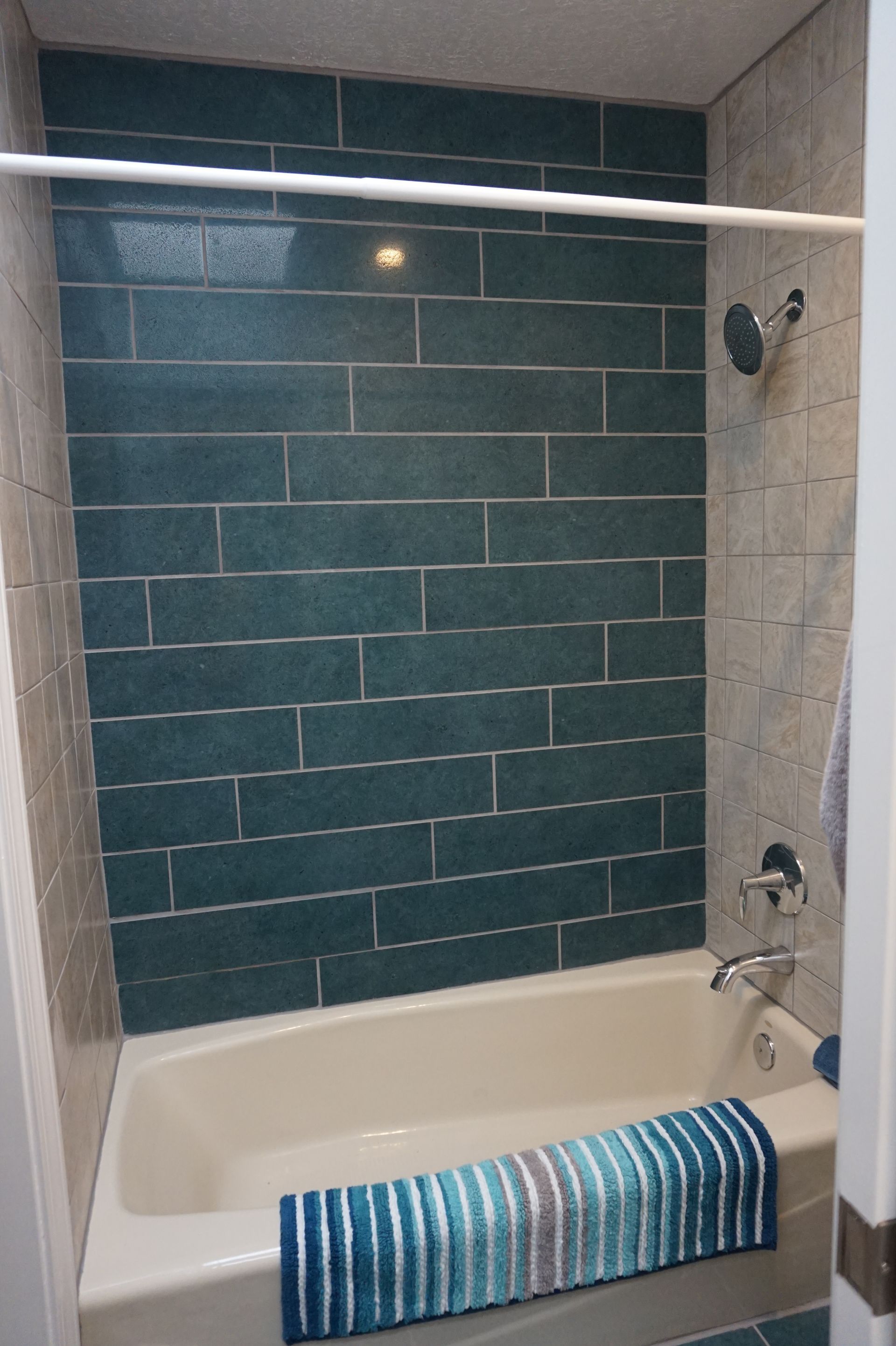 a bathtub in a bathroom with blue tiles on the wall