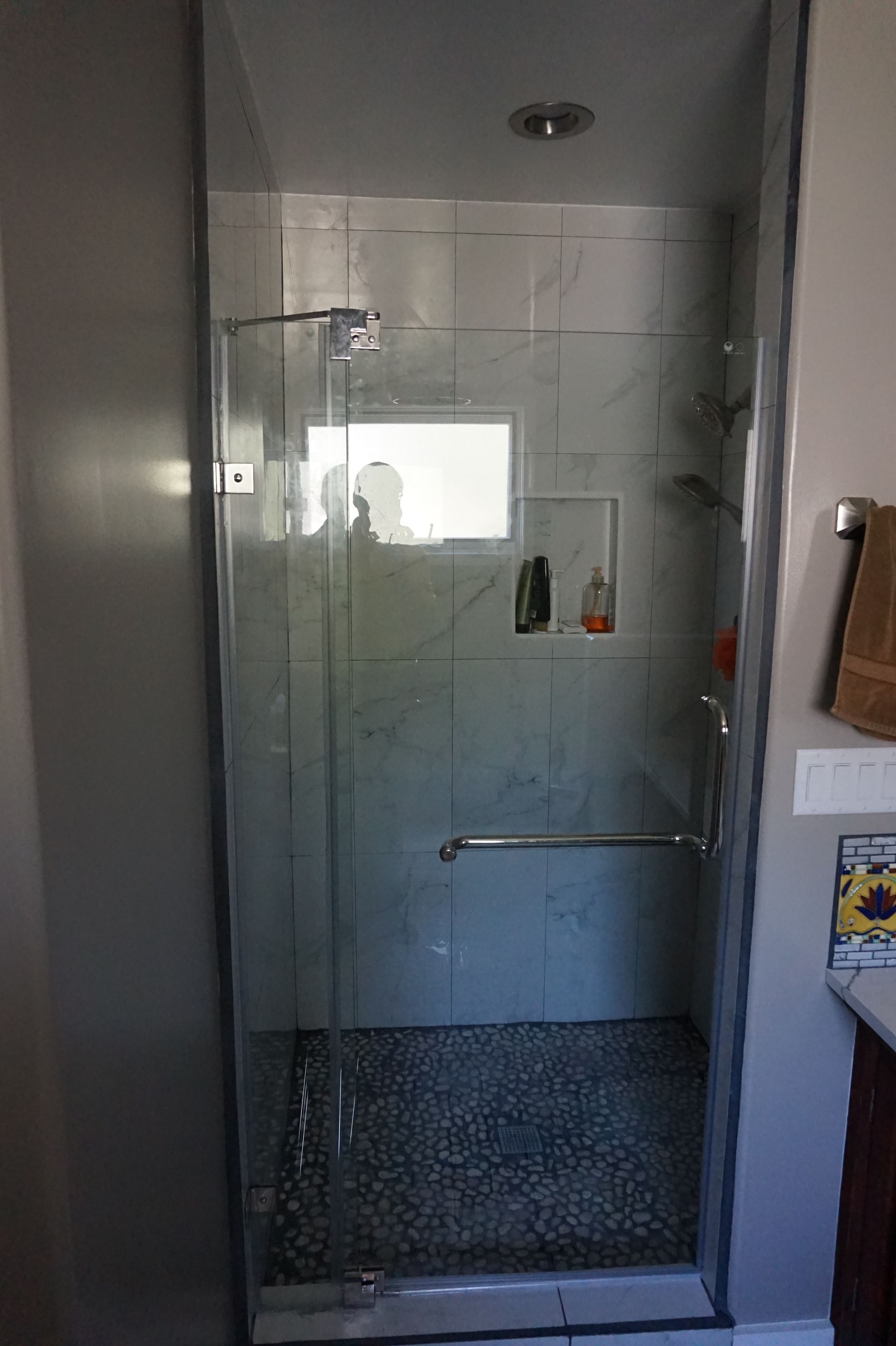 a bathroom with a walk in shower with a glass door