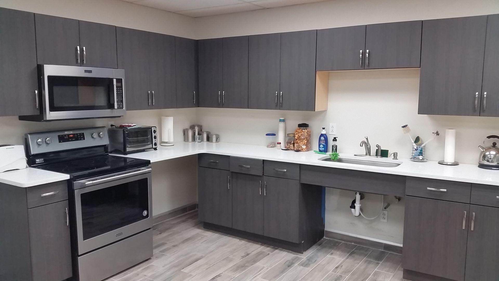 a kitchen with stainless steel appliances and gray cabinets