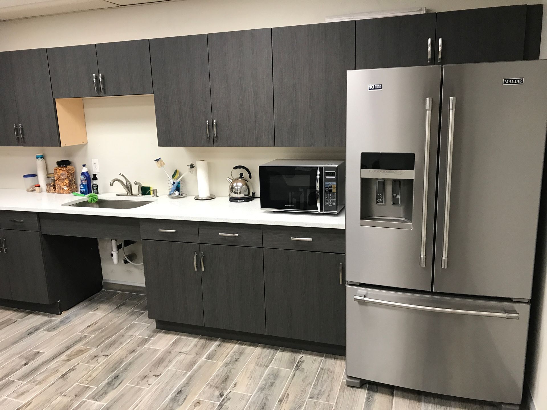 a kitchen with stainless steel appliances and gray cabinets