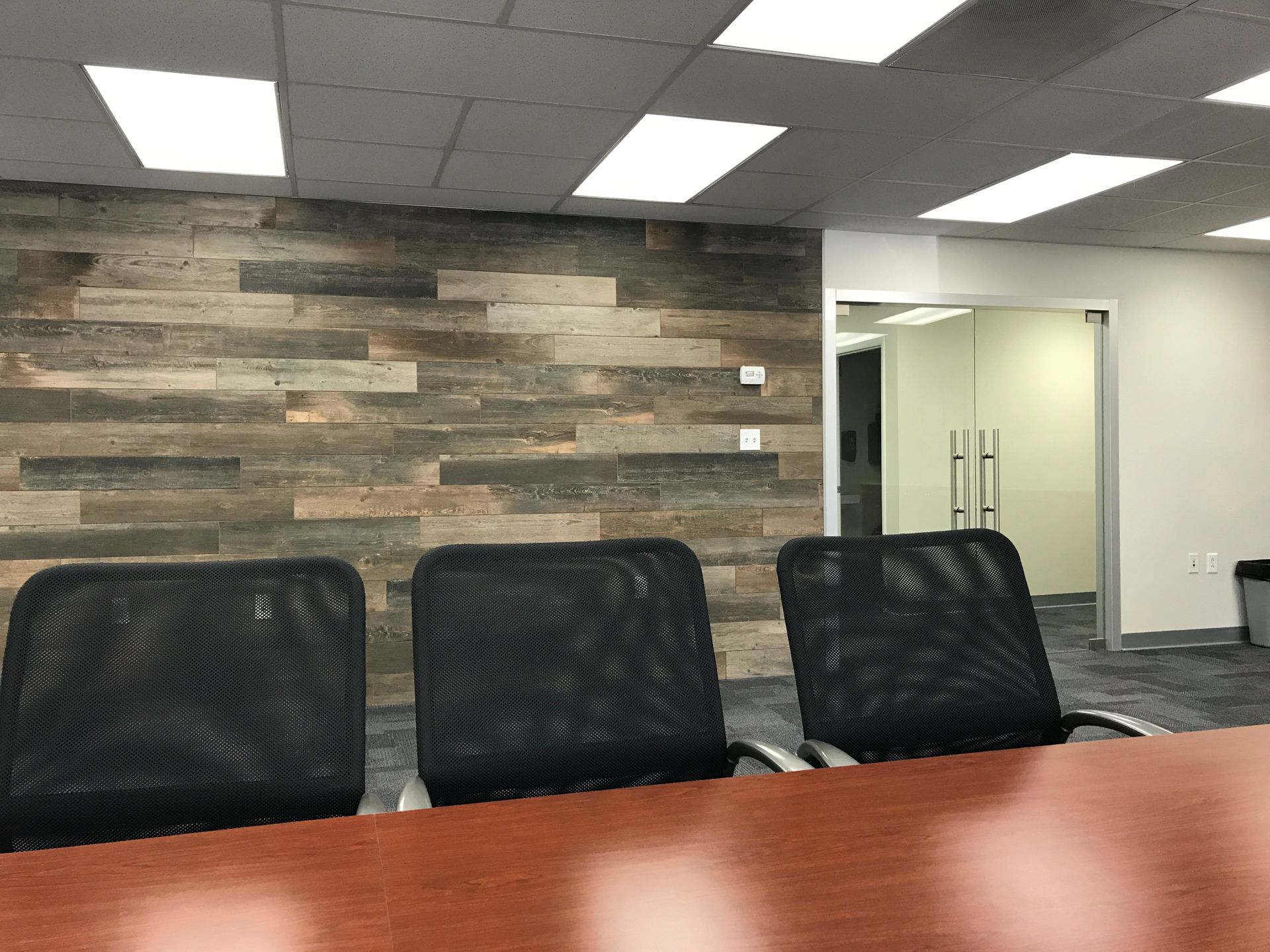 a conference room with a wooden wall and a table and chairs
