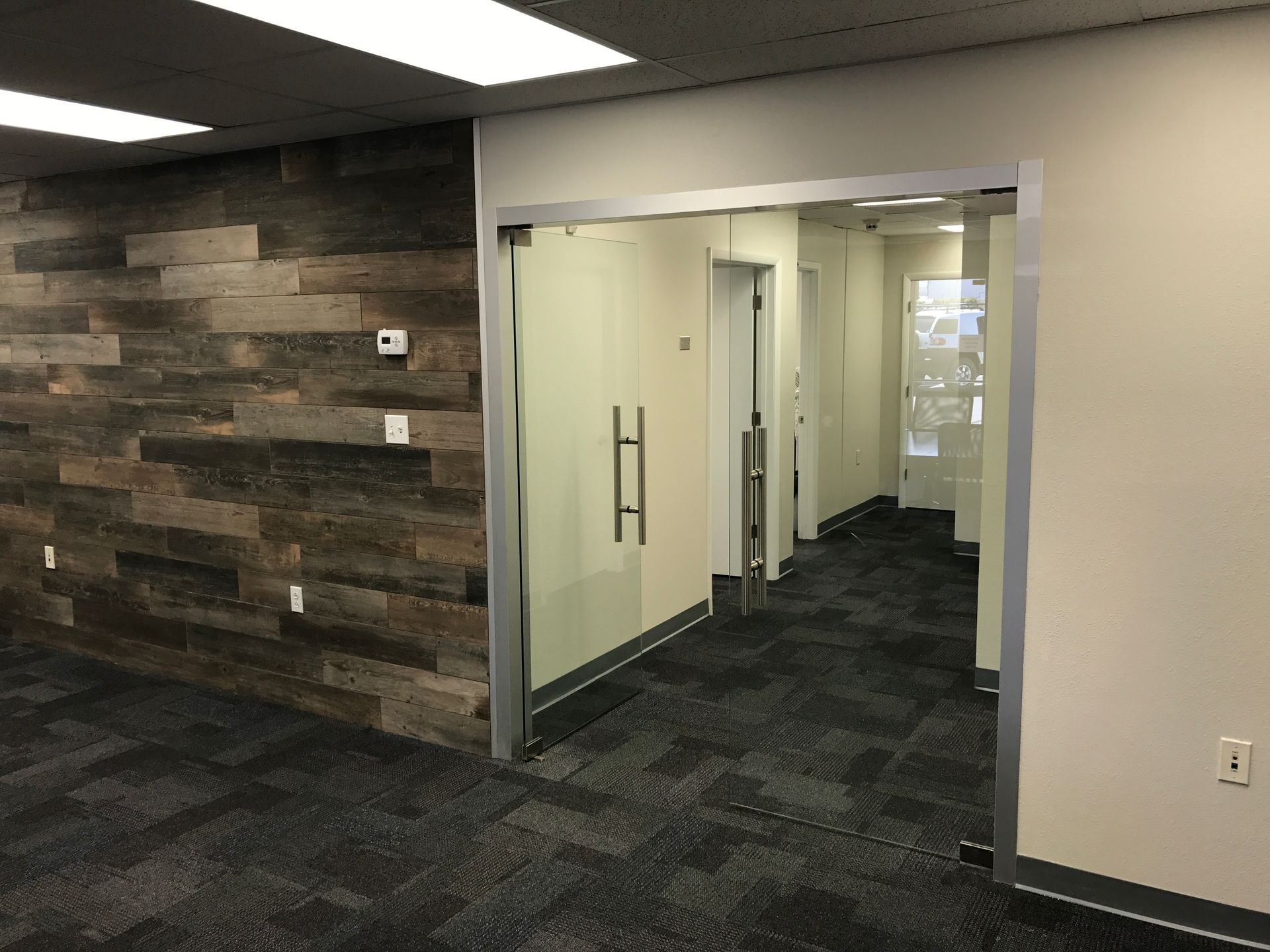 a room with a wooden wall and a glass door