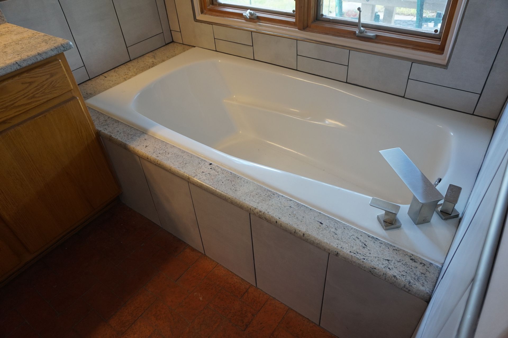 a bathtub in a bathroom next to a window