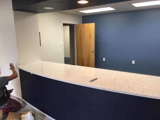 a man is working on a counter in a room with blue walls