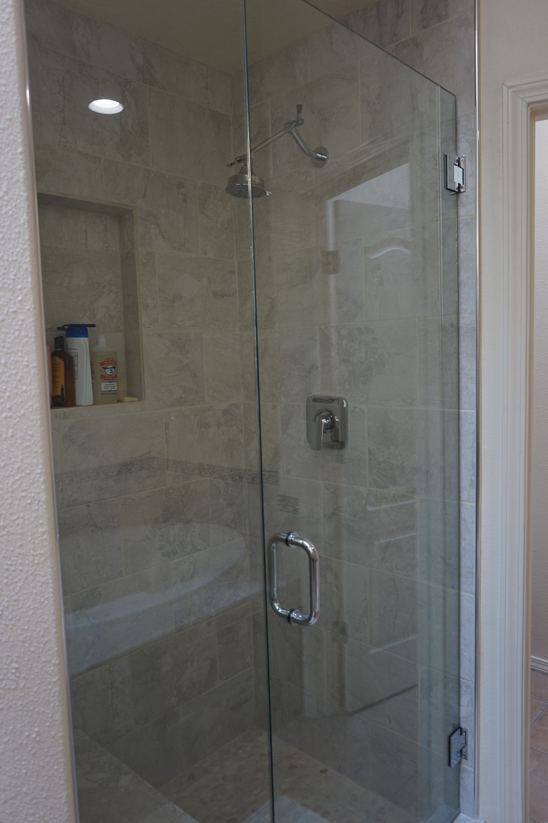 a bathroom with a glass shower door and a bathtub