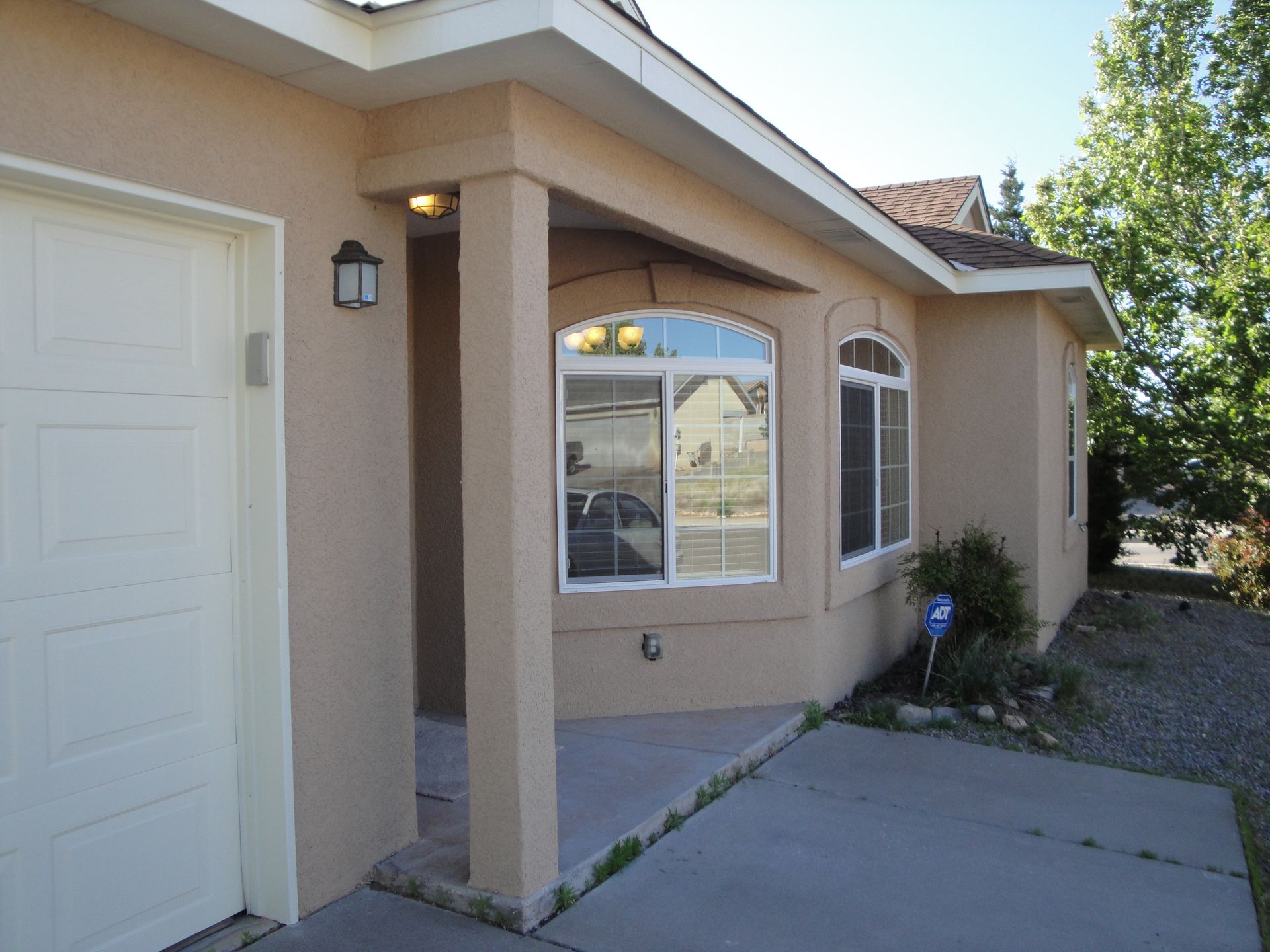 a house with a white garage door and a large window