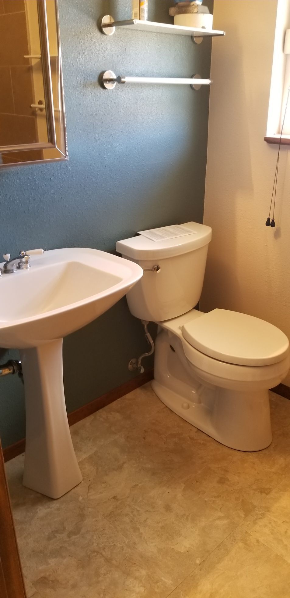 a bathroom with a toilet, sink and mirror
