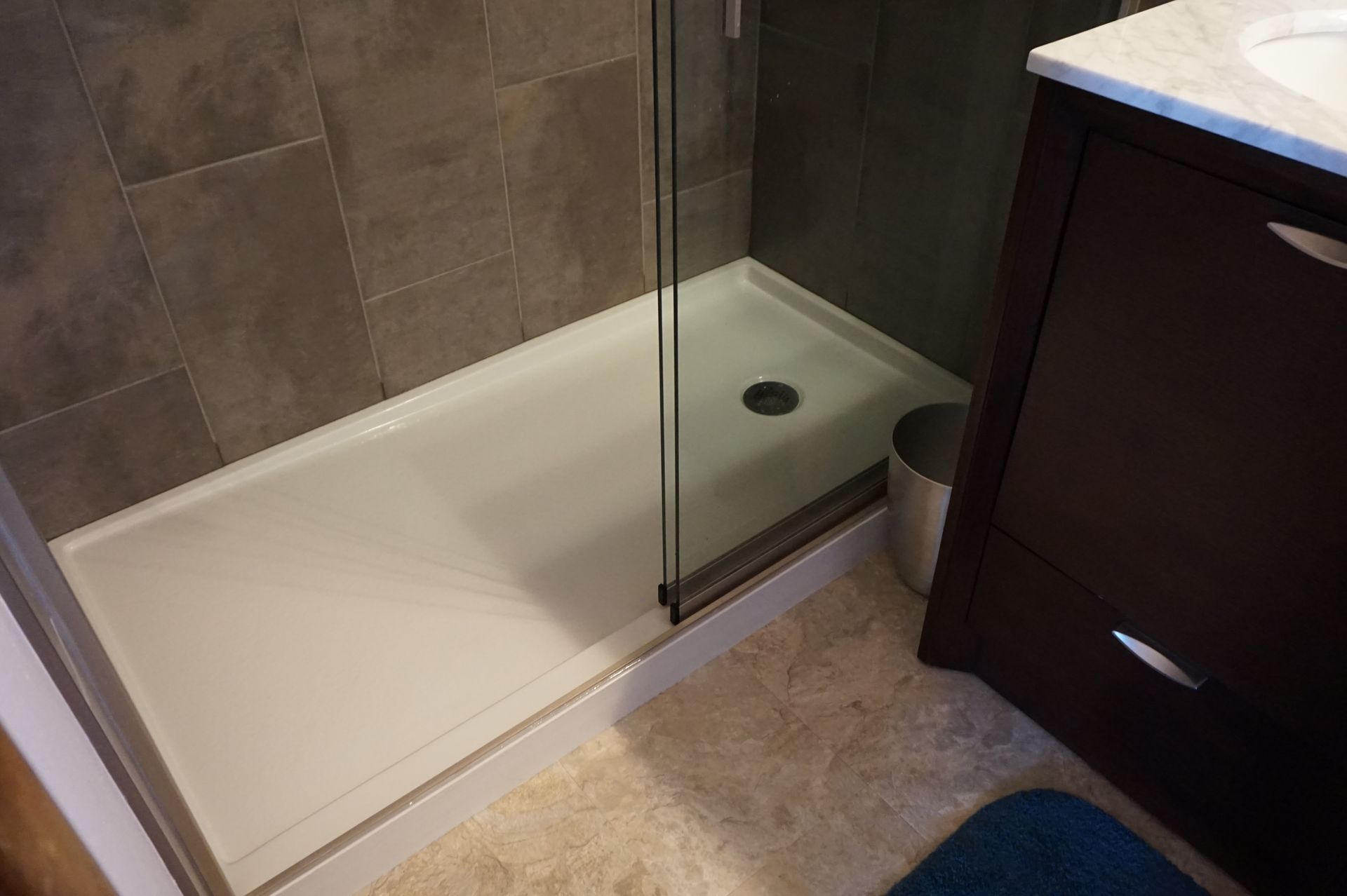 a bathroom with a walk in shower and a sink