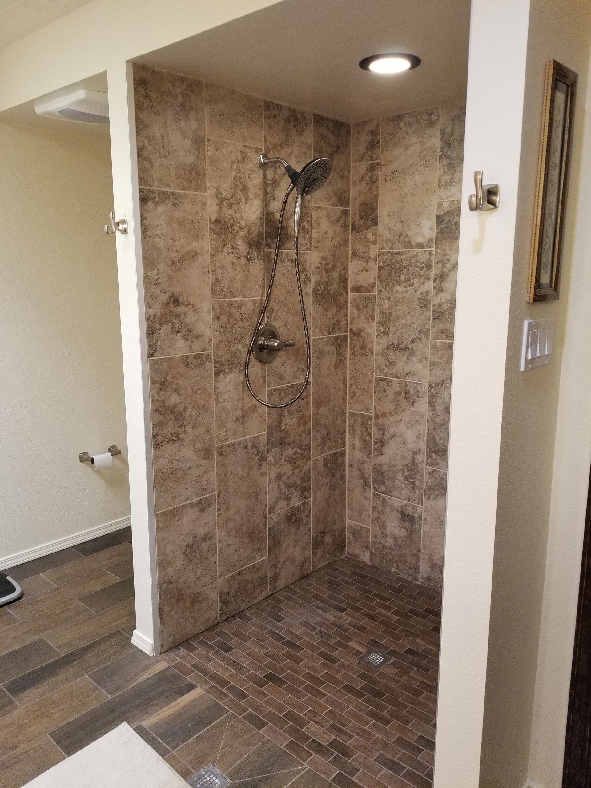 a bathroom with a walk in shower and a picture on the wall