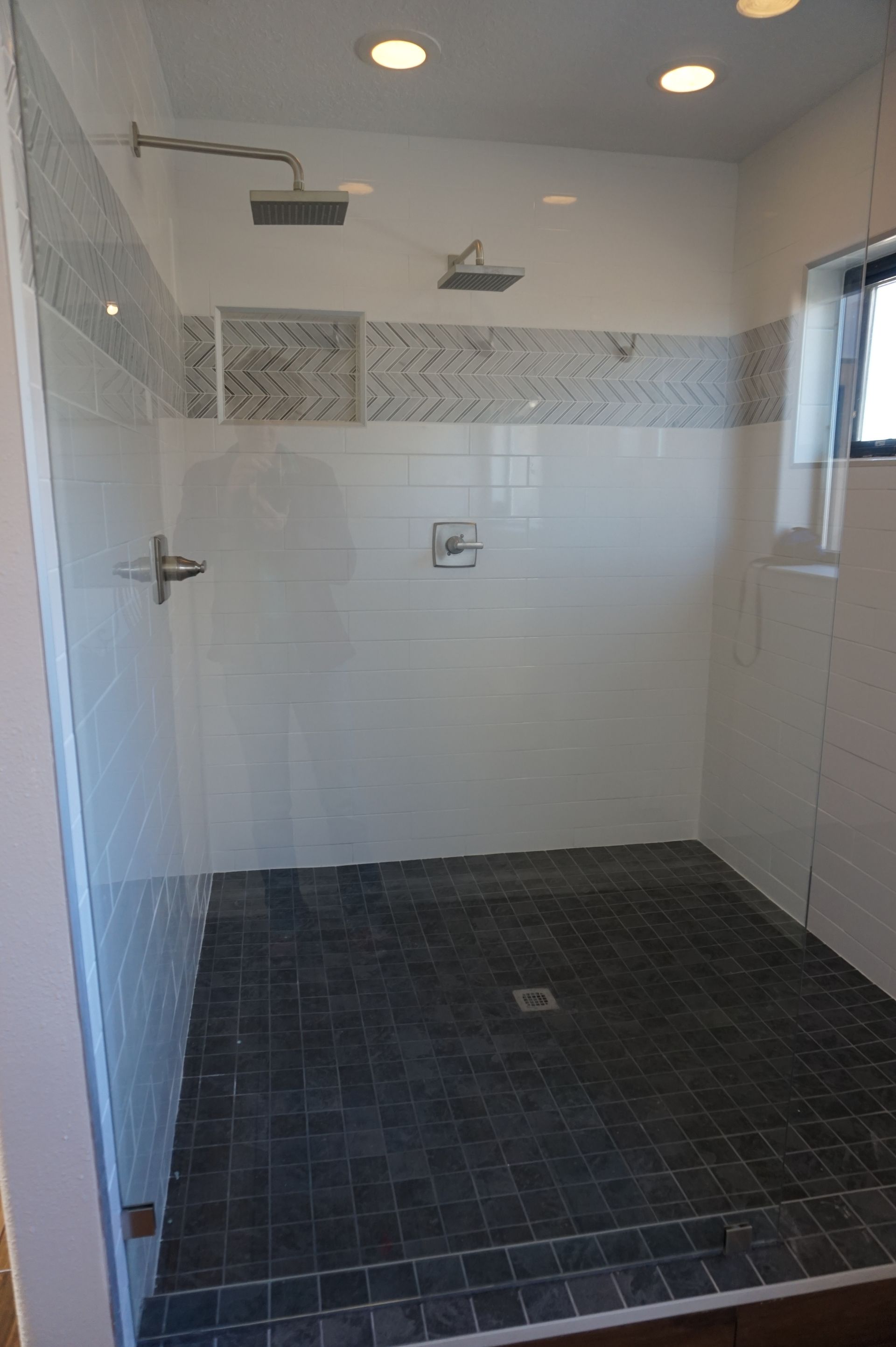 a walk in shower with a glass door and a shower head