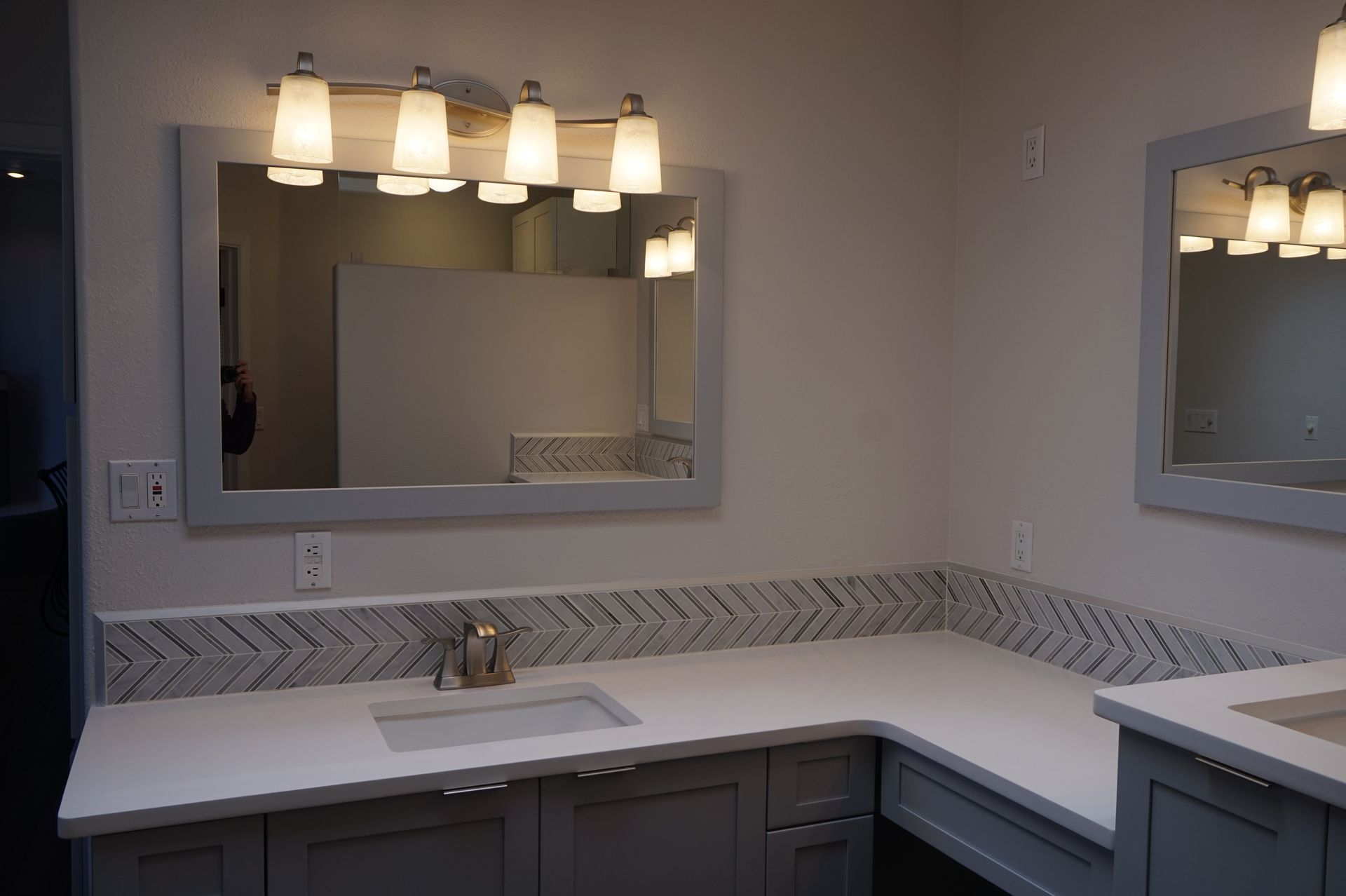 a bathroom with two sinks and two mirrors