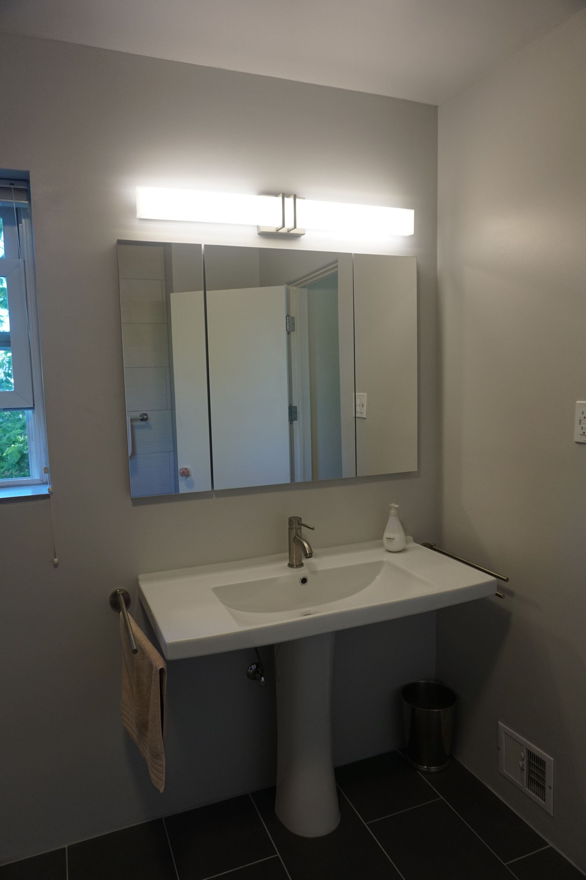 a bathroom with a sink a mirror and a window