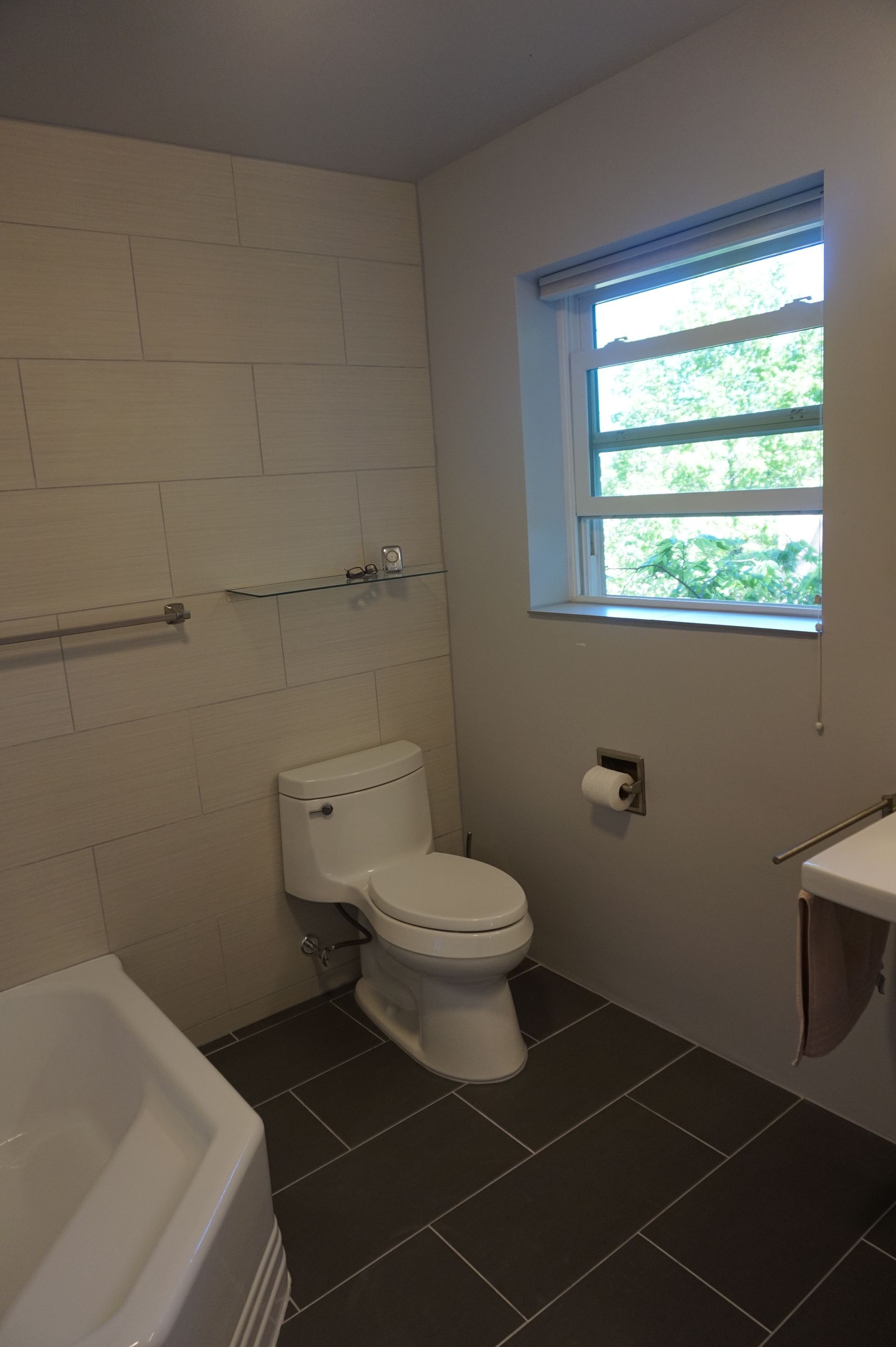 a bathroom with a toilet, sink, and window