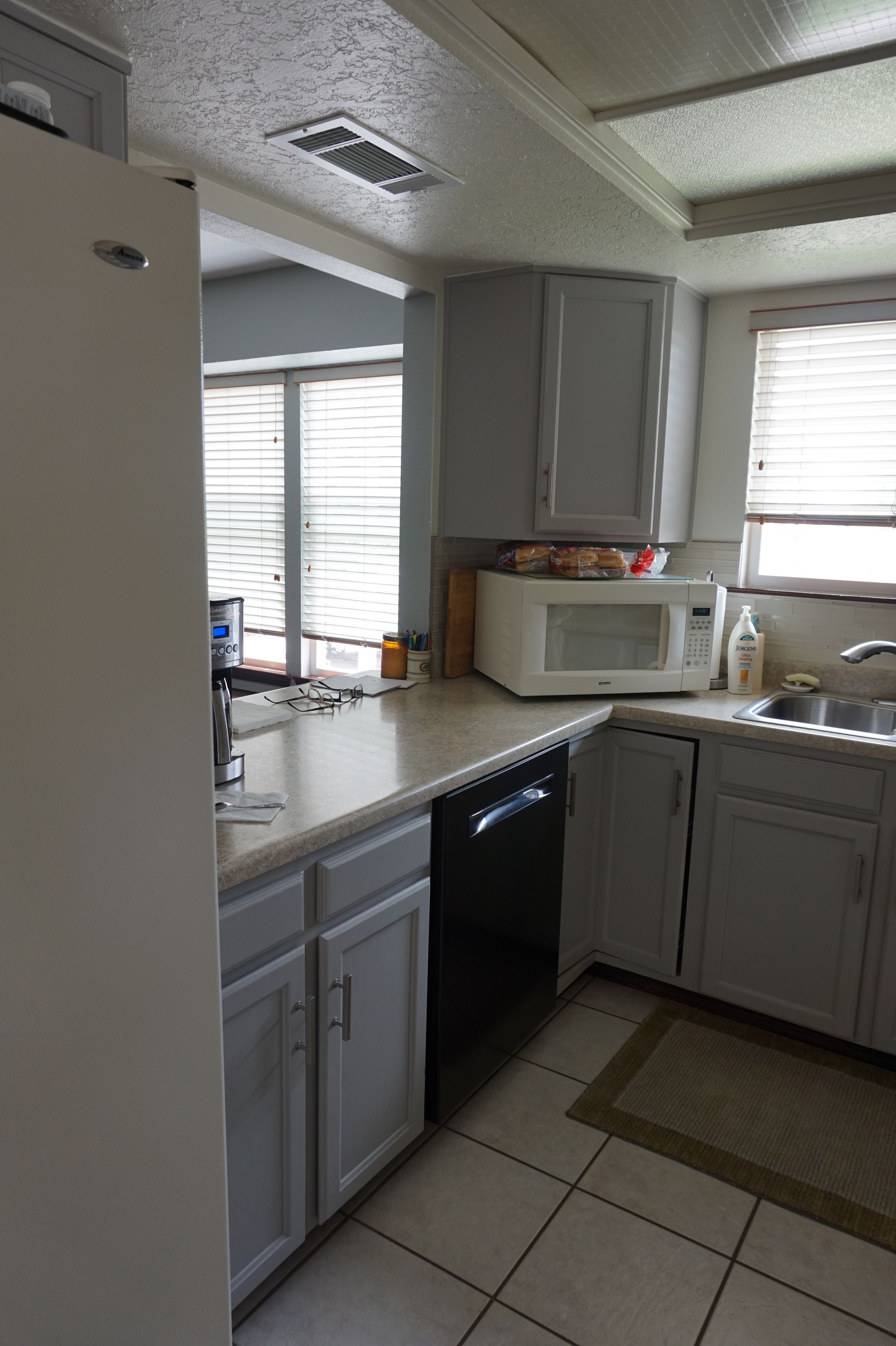 a kitchen with a refrigerator, dishwasher, microwave and sink