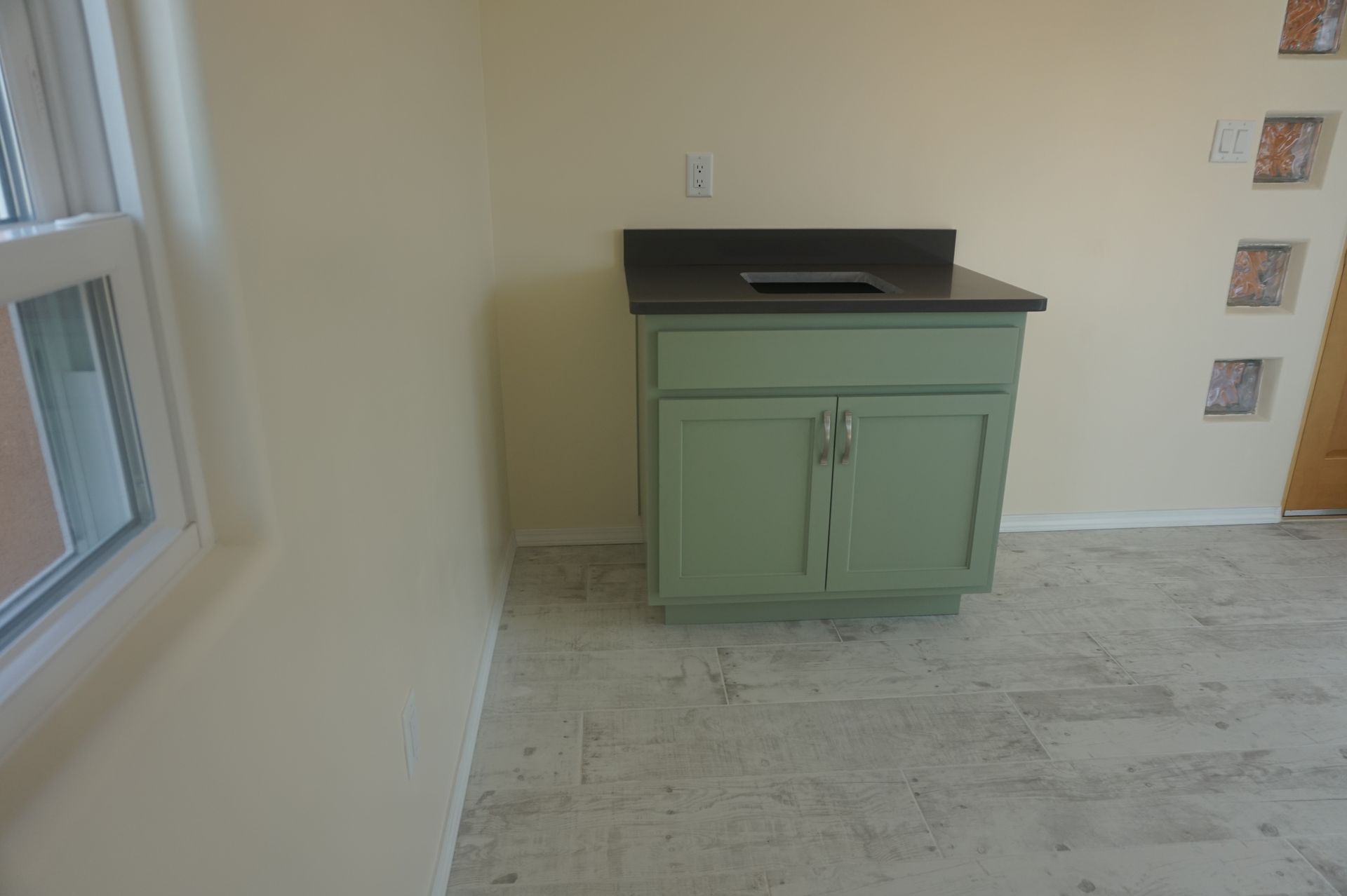 an empty room with a green cabinet and a sink