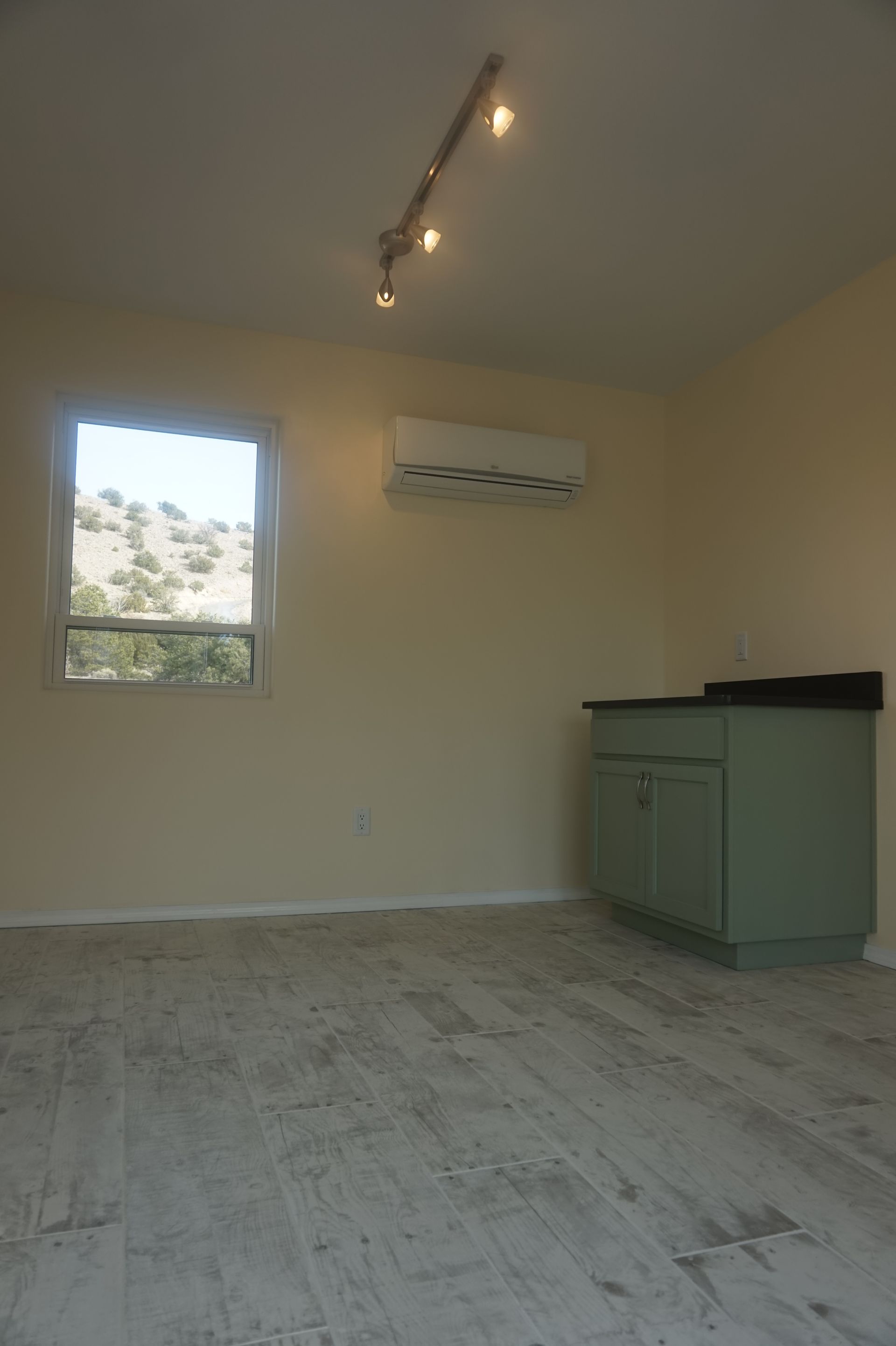 an empty room with a window and a ceiling fan