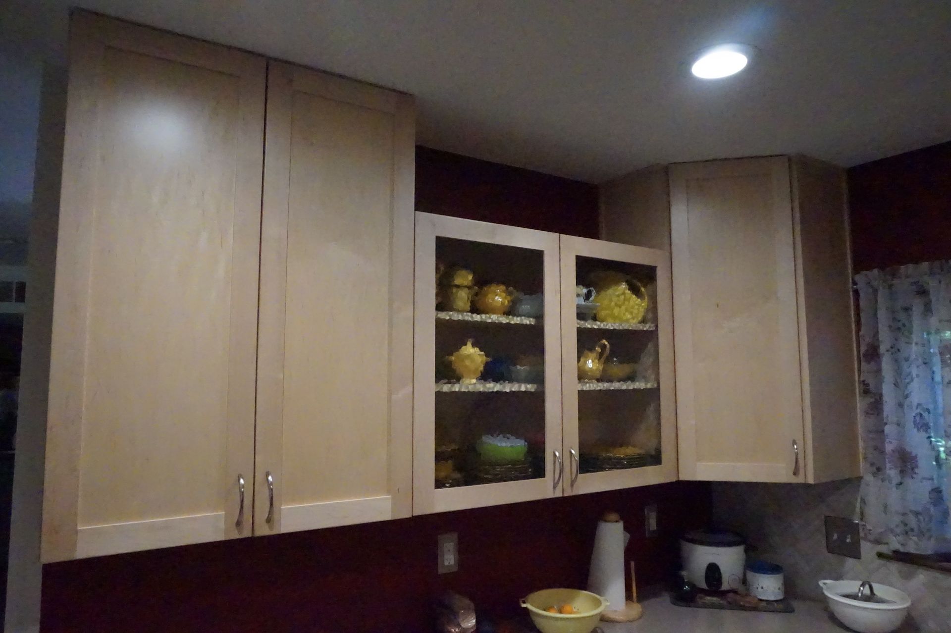 a kitchen with wooden cabinets and glass doors