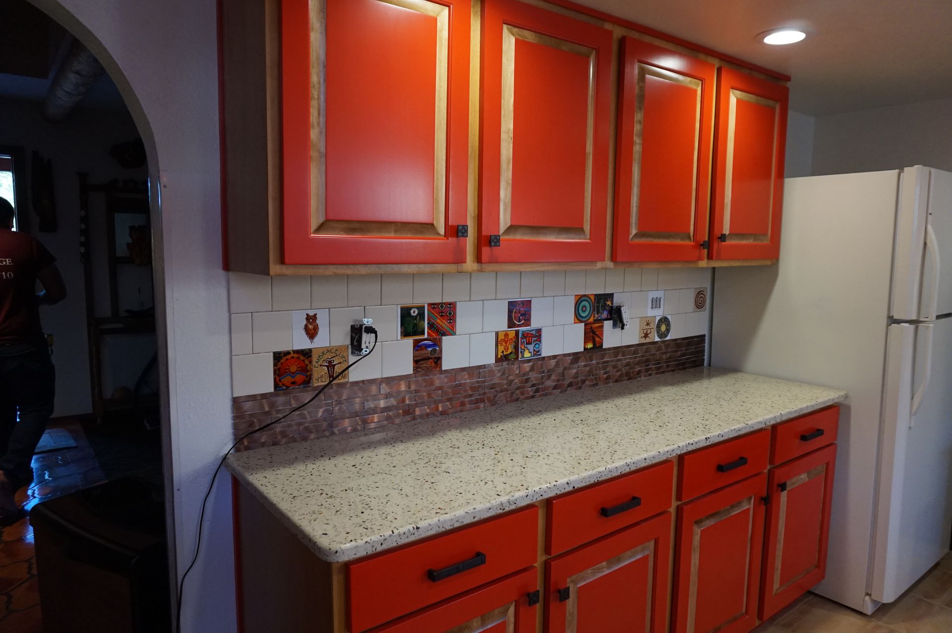 a kitchen with red cabinets and a white refrigerator