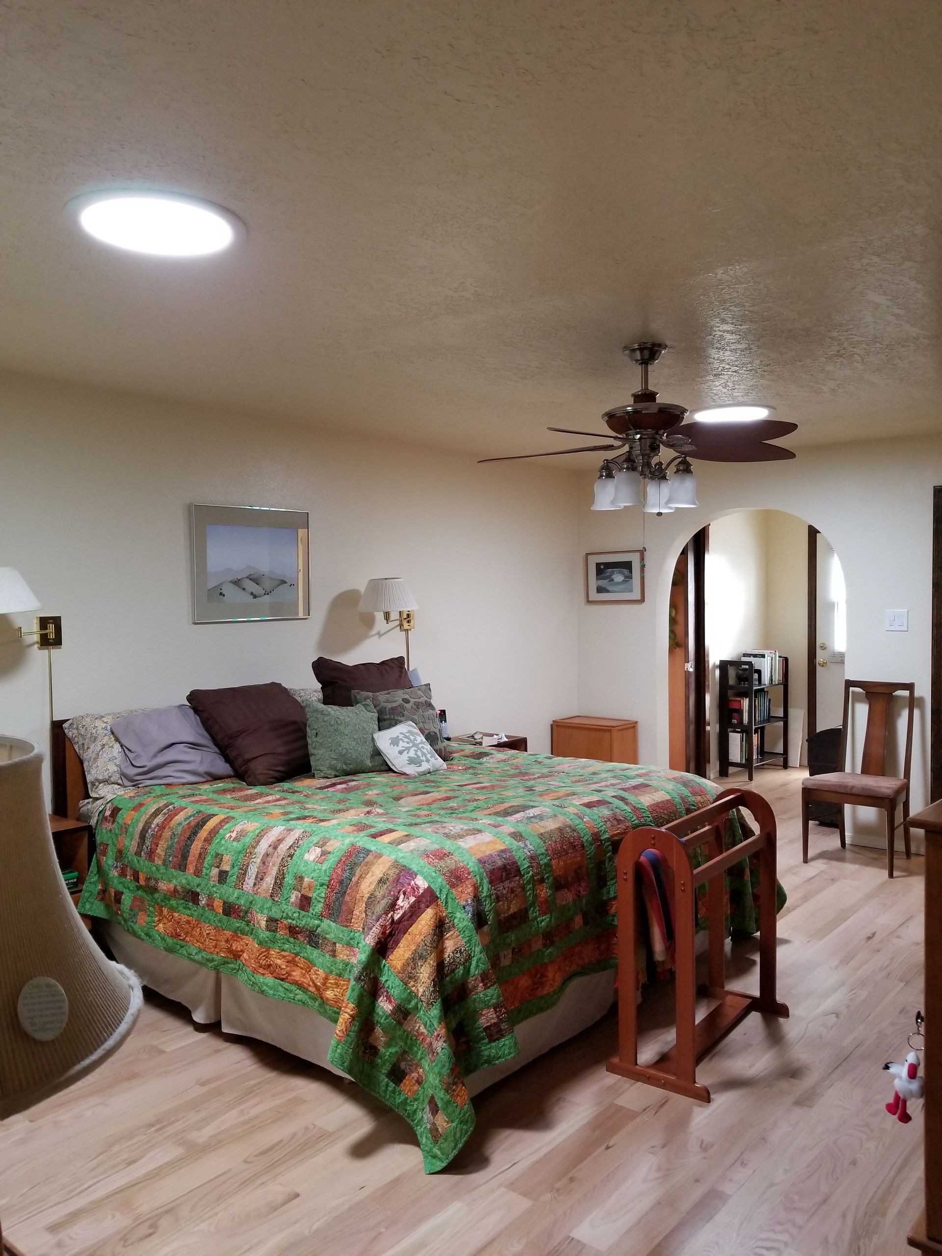 a bedroom with a large bed and a ceiling fan