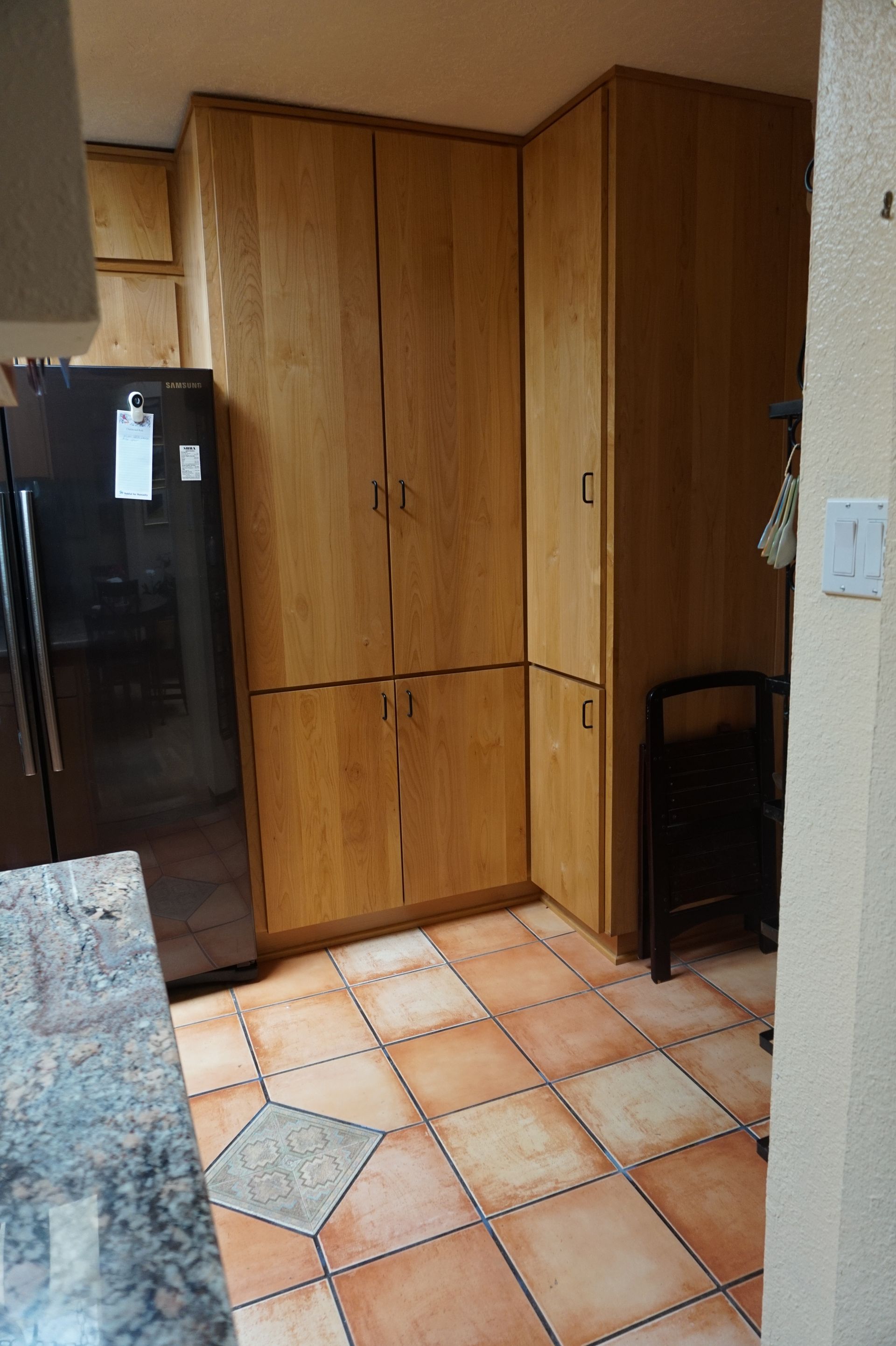 a kitchen with wooden cabinets and tile floors