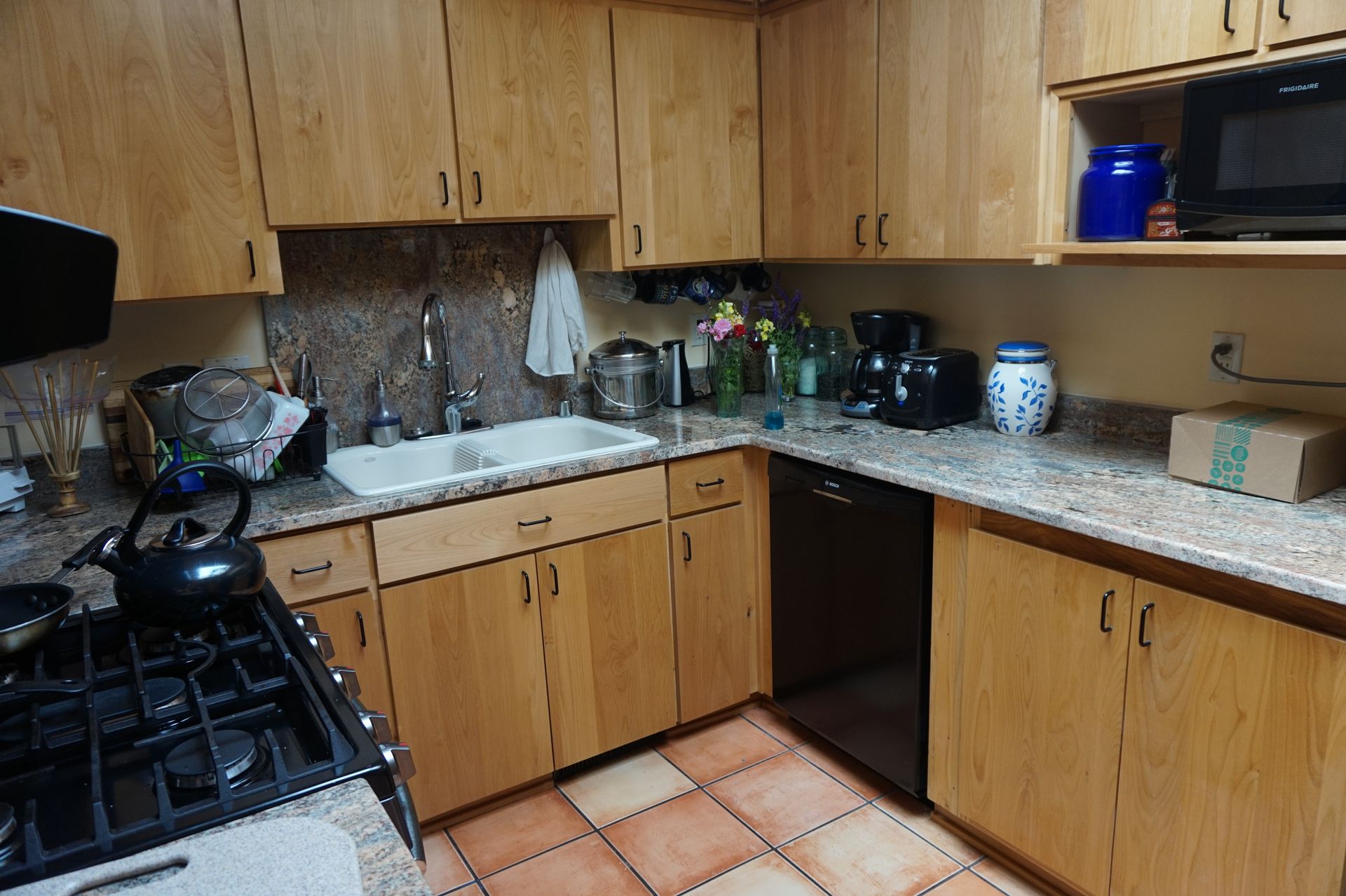 a kitchen with wooden cabinets and granite counter tops