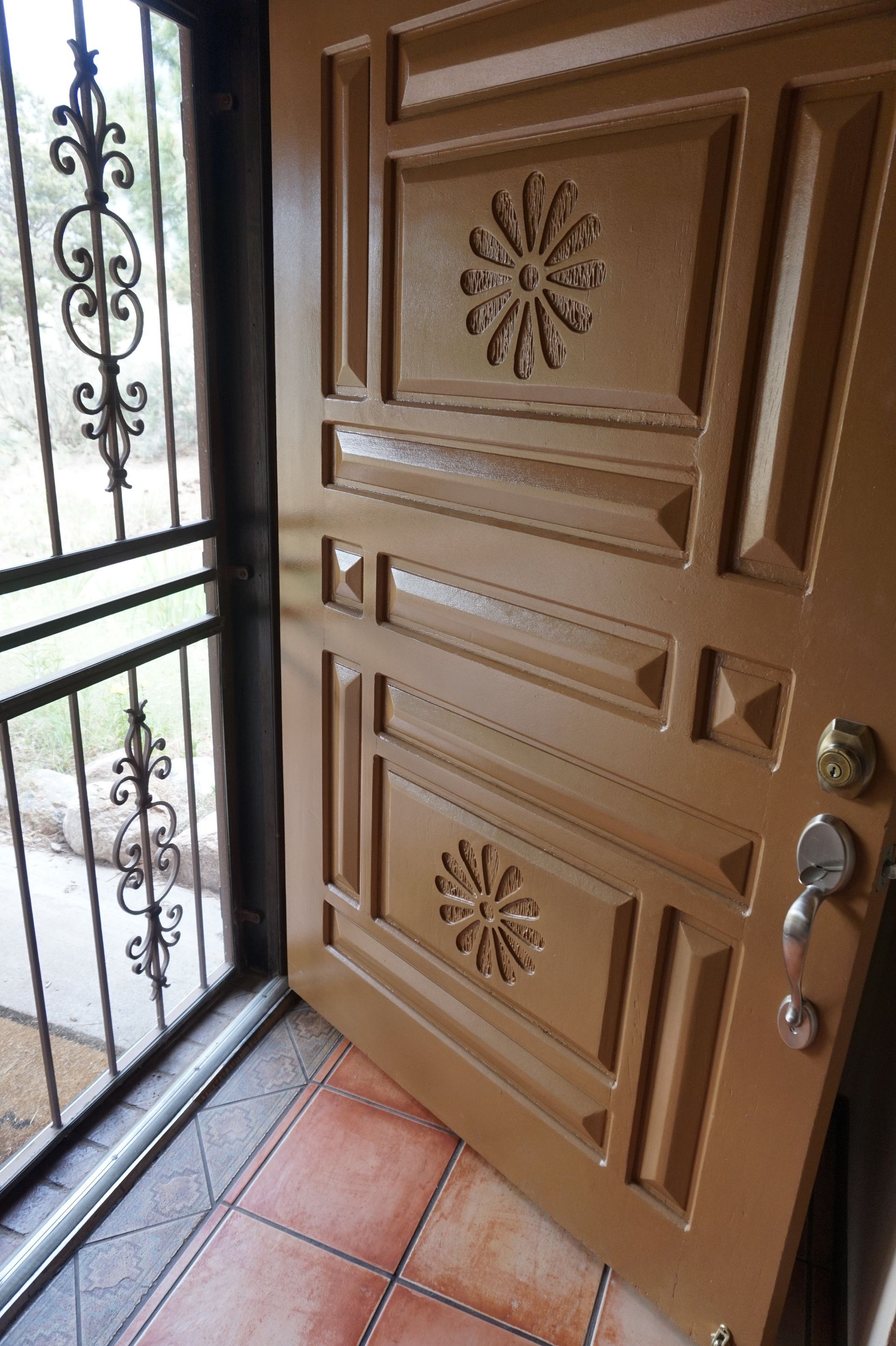 a door with a wrought iron gate and a floral design on it