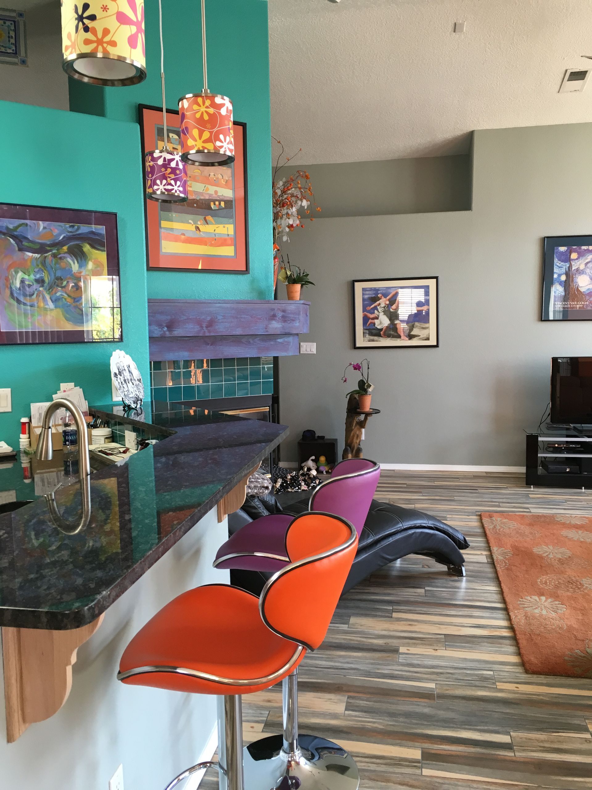 a living room with a fireplace and orange bar stools