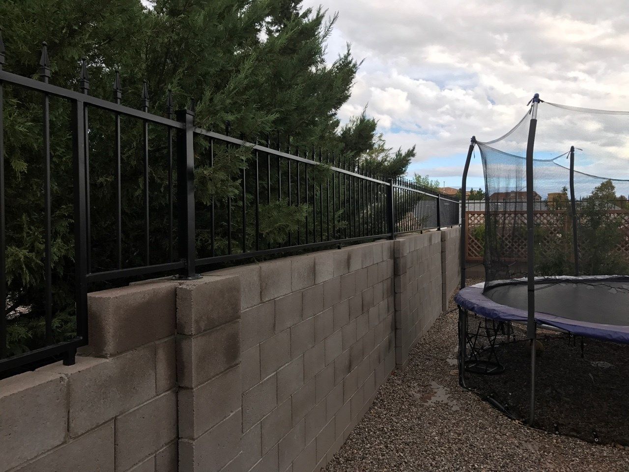 a trampoline is sitting next to a brick wall