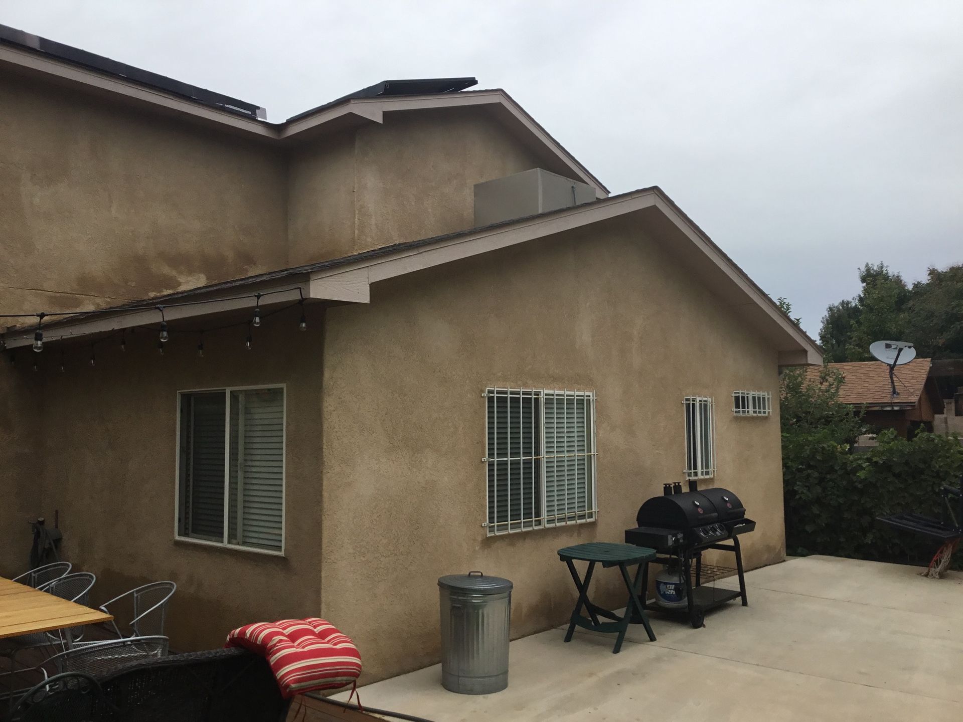 a house with a grill and a table in front of it