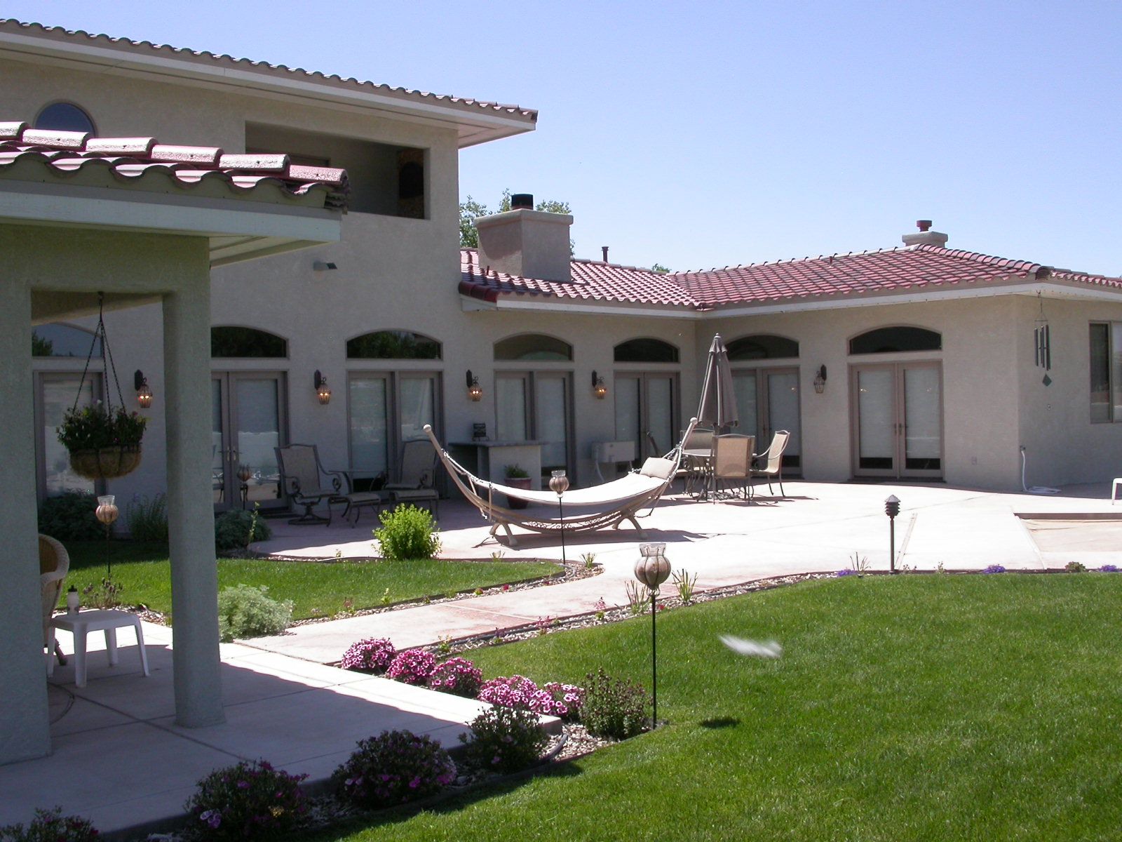 a large white house with a hammock in the backyard