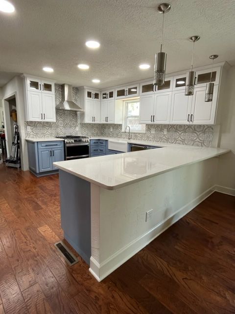a kitchen with white cabinets and wooden floors