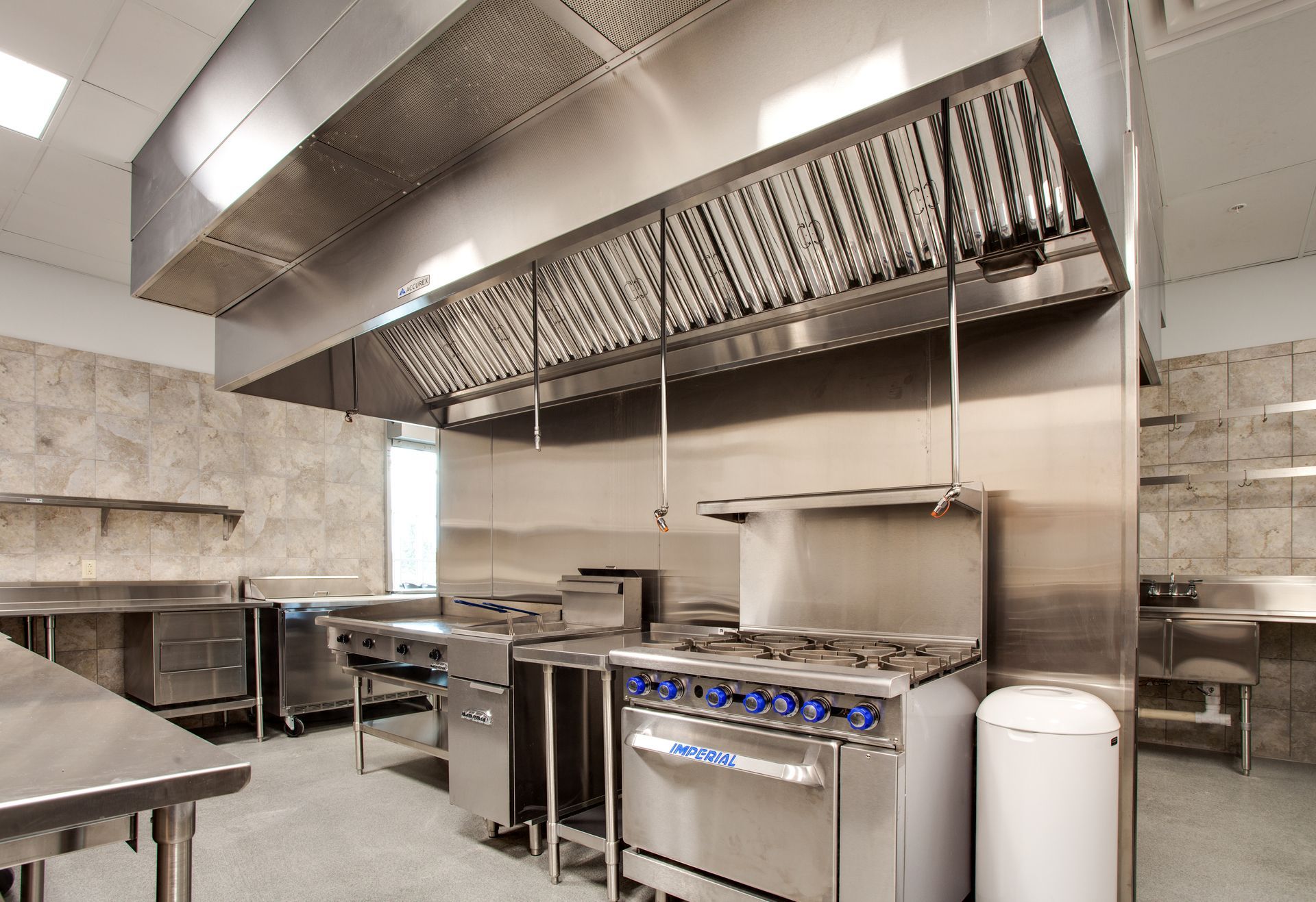 a kitchen with stainless steel appliances and a trash can