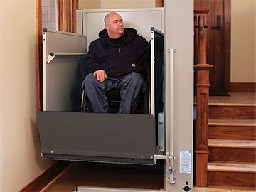 A man patiently waiting on a wheelchair lift