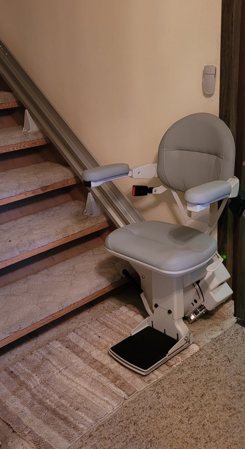 A stair lift is sitting next to a set of stairs