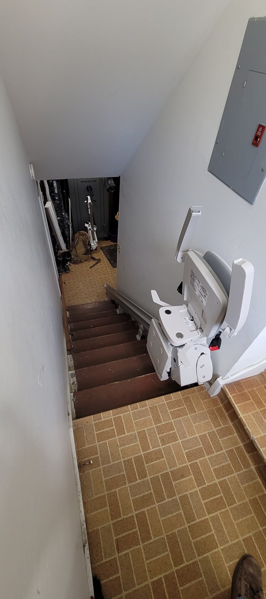 A stair lift is sitting on the bottom of a set of stairs
