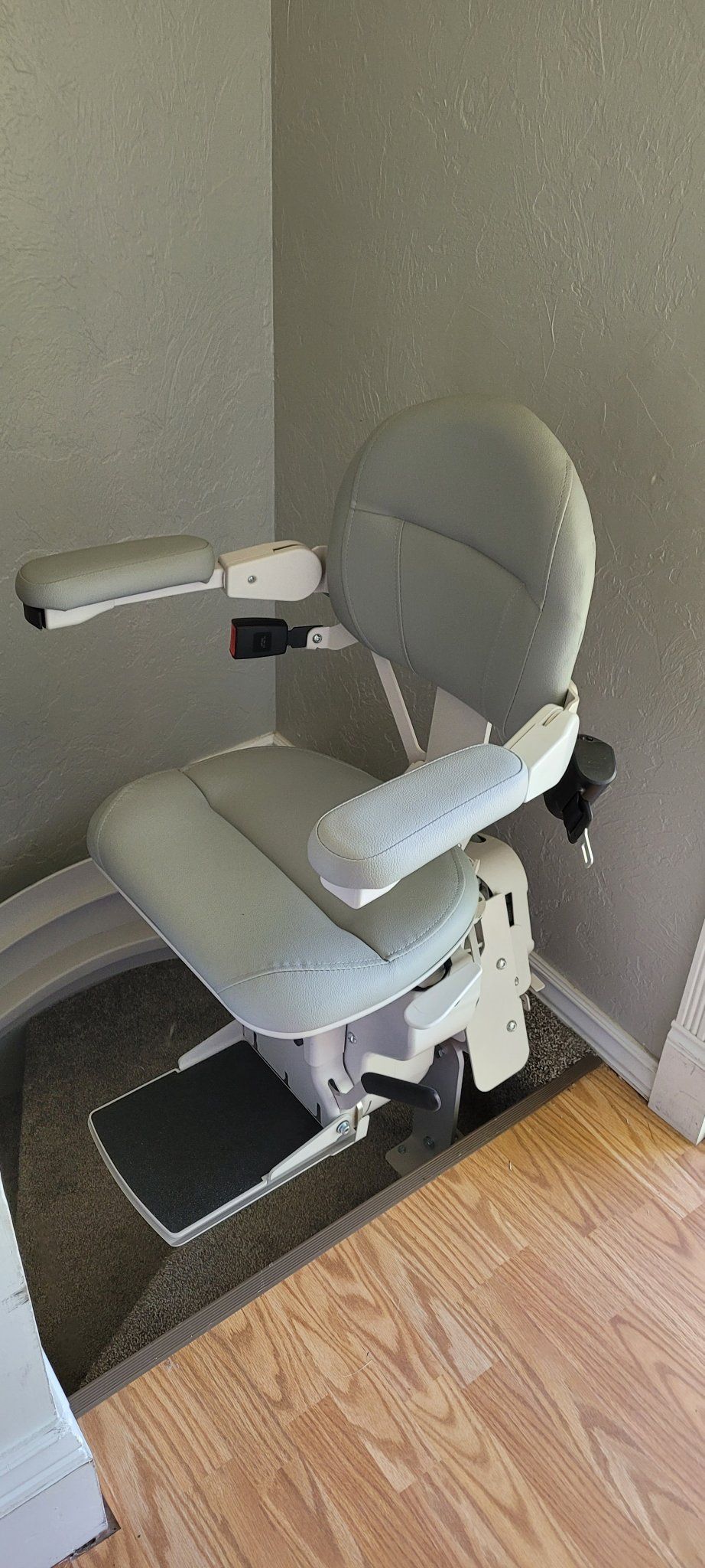 A stair lift is sitting in a corner of a room