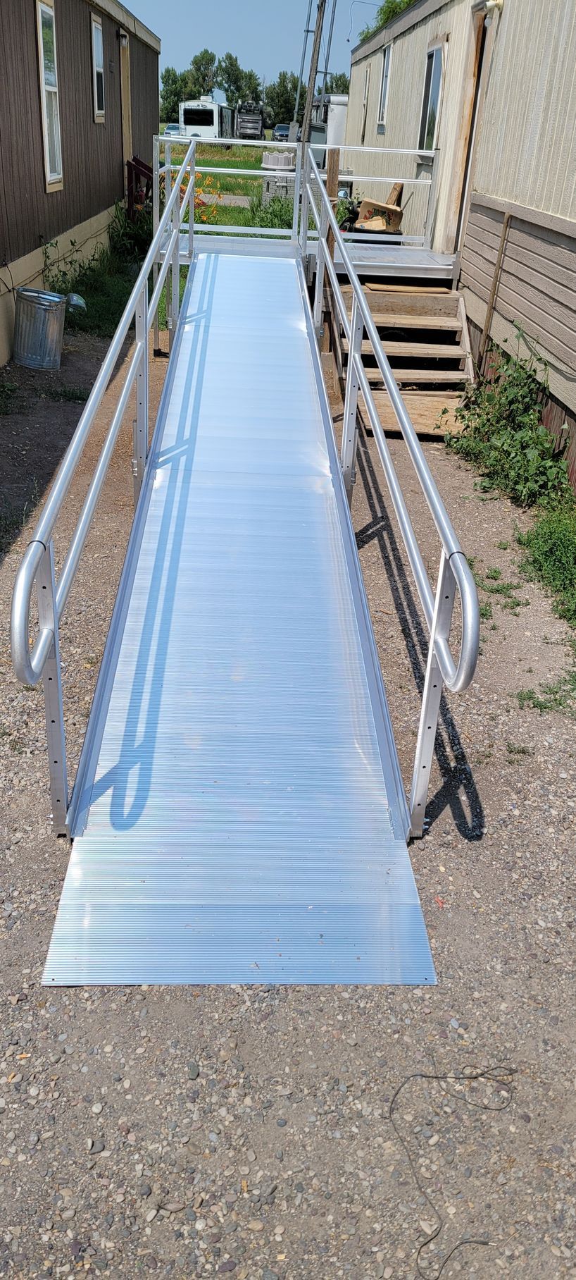 A metal ramp with a railing in front of a mobile home